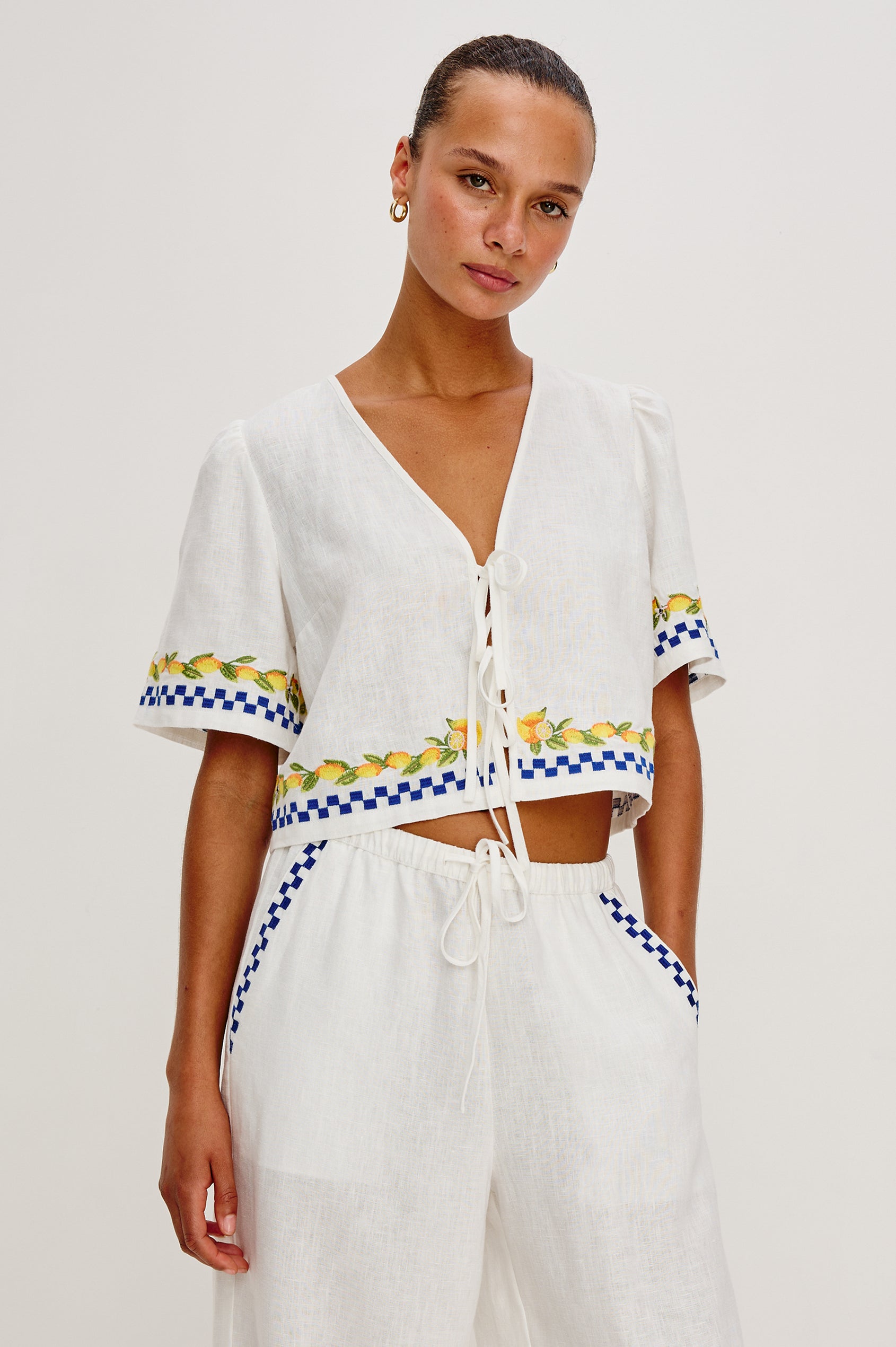 Pari linen top in Sorrento Embroidery colorway. Featuring front tie closures and Italian inspired embroidery - front view on model