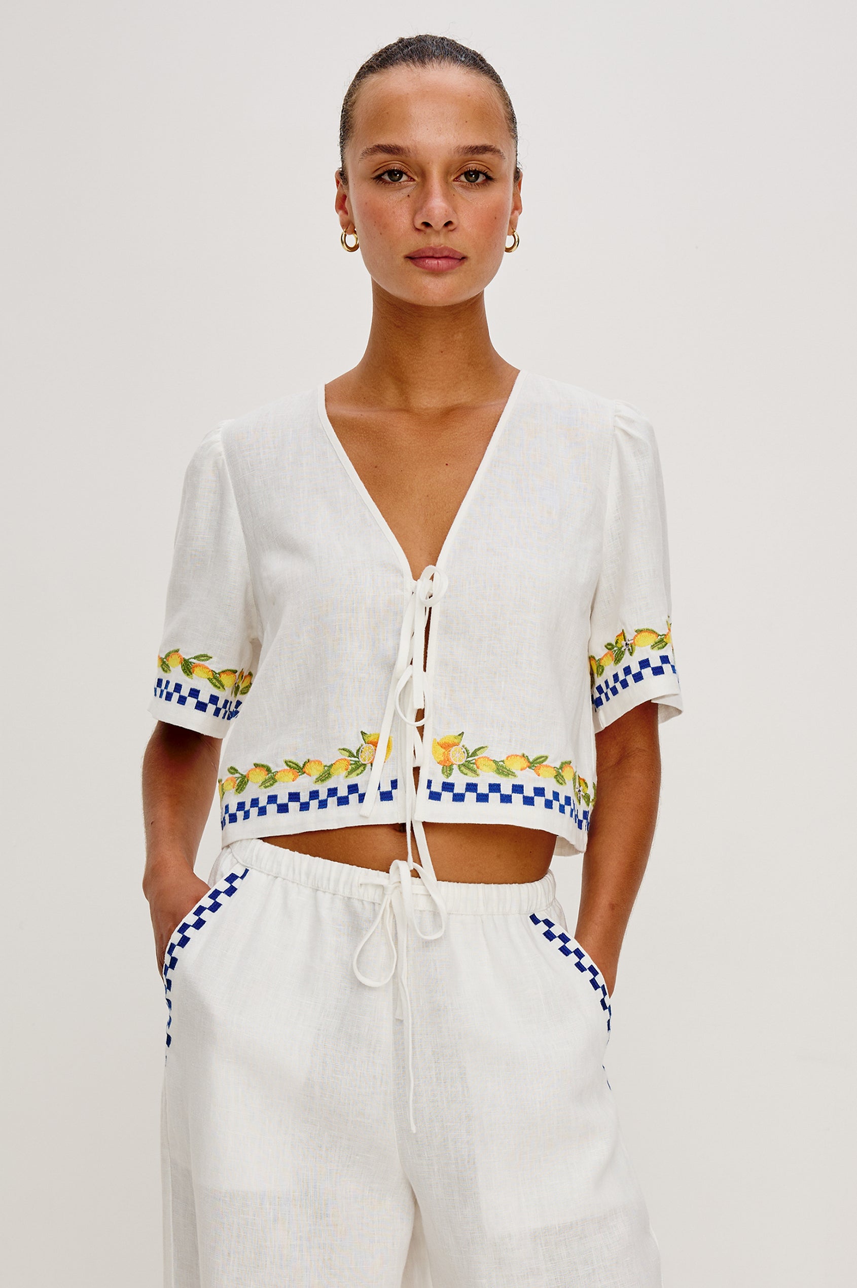 Pari linen top in Sorrento Embroidery colorway. Featuring front tie closures and Italian inspired embroidery - front view on model