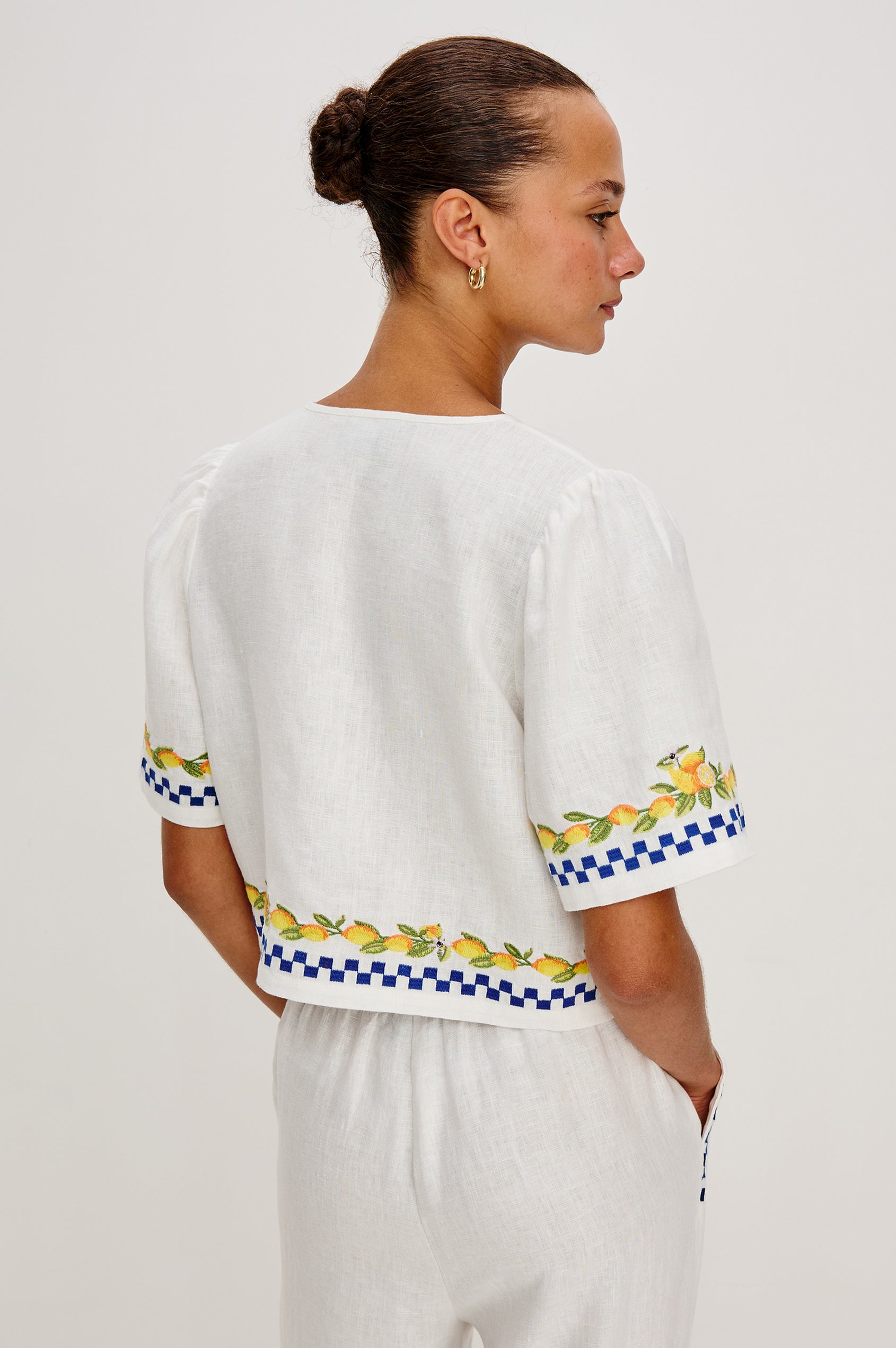 Pari linen top in Sorrento Embroidery colorway. Featuring front tie closures and Italian inspired embroidery - back view on model