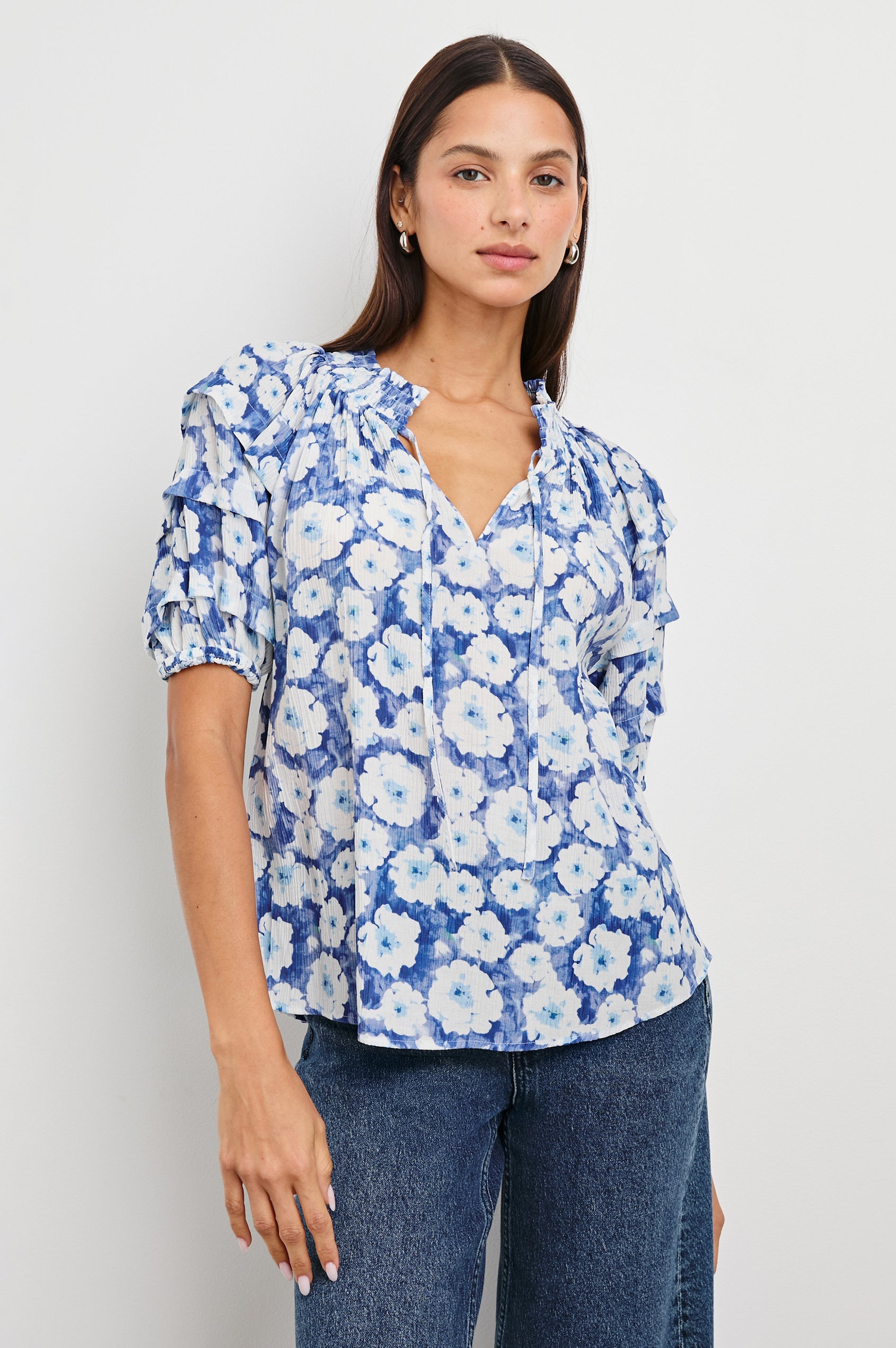Paris Short-Sleeve Top with Shirred Collar, V-neckline with Ties, Deep Pleats on Sleeves and Elastic at the Sleeve Opening in Blue Floral Colorway, Blues and White - Front Untucked View Featured on Model