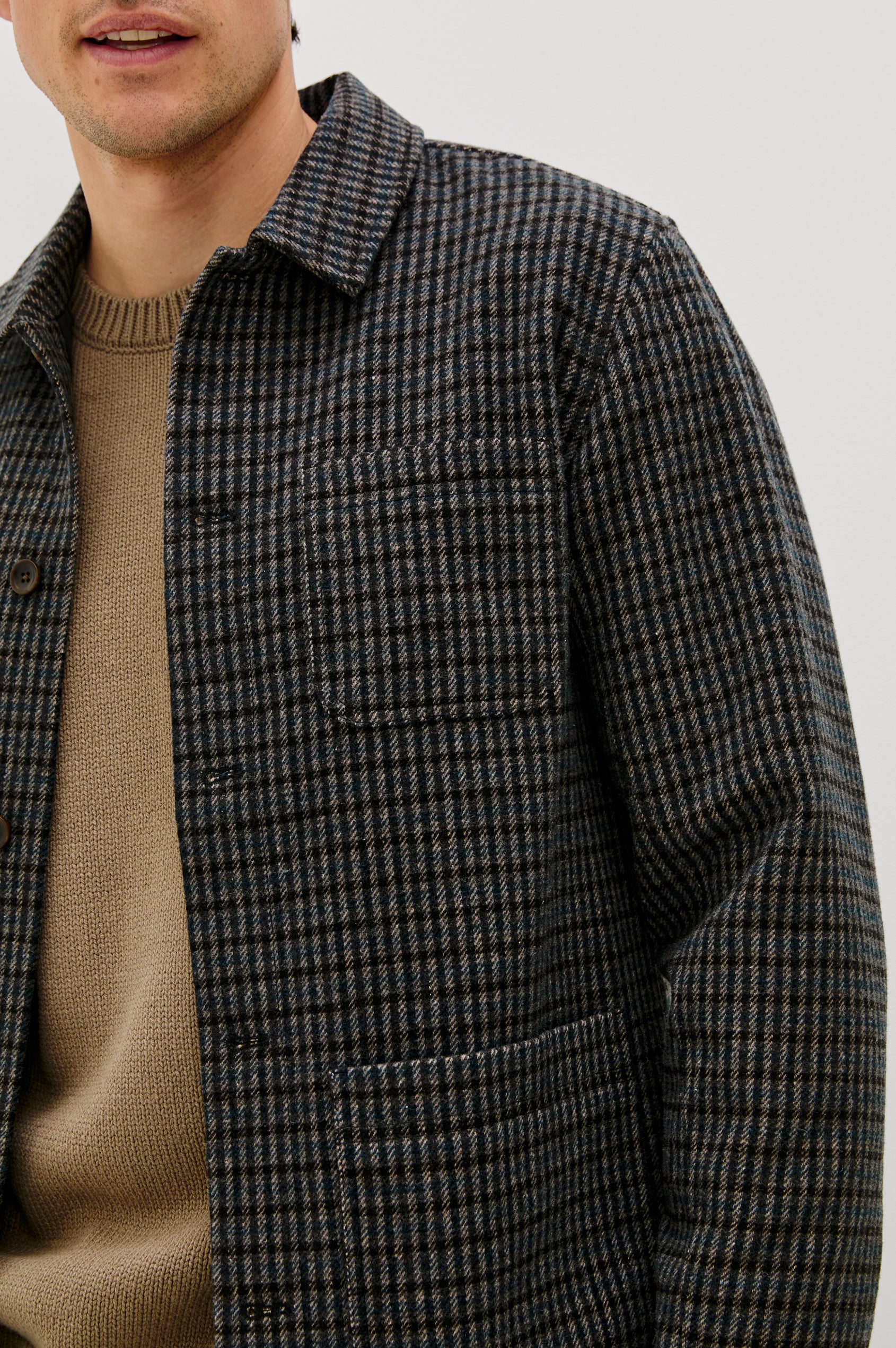 The Pascal is a collared button front jacket with front patch pockets and a chest pocket in Grey Check Plaid colorway. Front detail view featured on model.