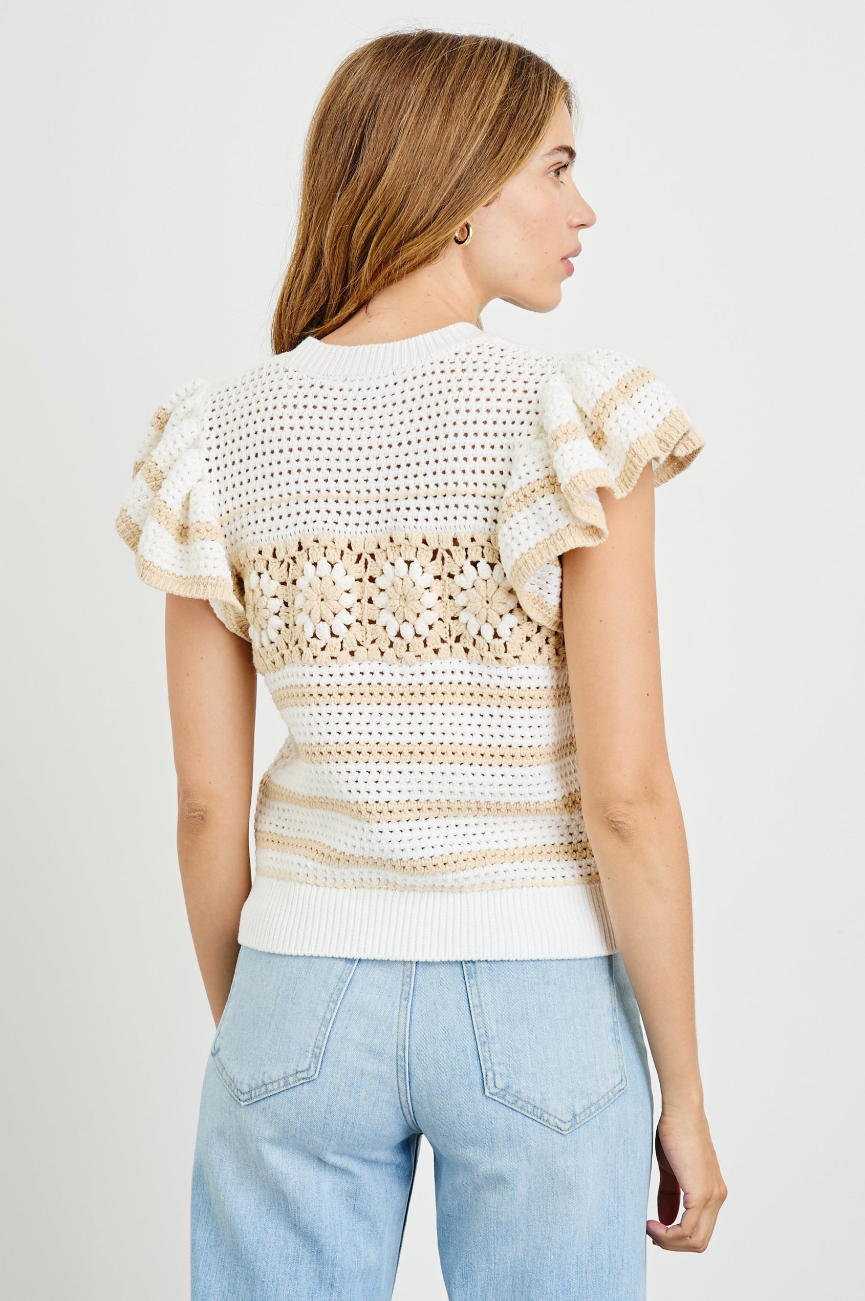 Penelope Crochet Top with Flutter Sleeves and Ribbed Hem in Ivory Oat Crochet Stripe Colorway, with contrasting knit flowers across the chest - Back View Featured on Model