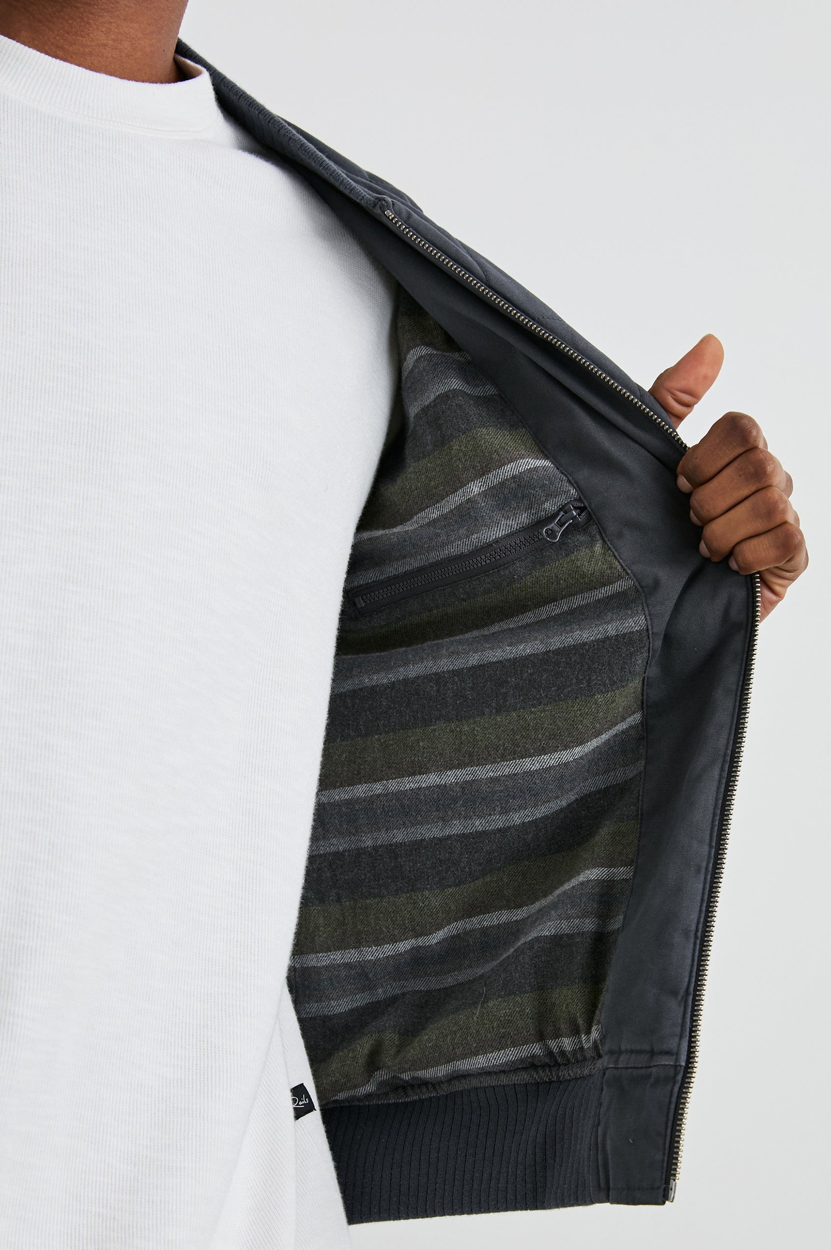 Peninsula Jacket with Zip Closure, Two Front Pockets, an Inner Zippered Pocket, a Quilted Pattern and Ribbed Trim in Obsidian Colorway - Interior View Featured on Model