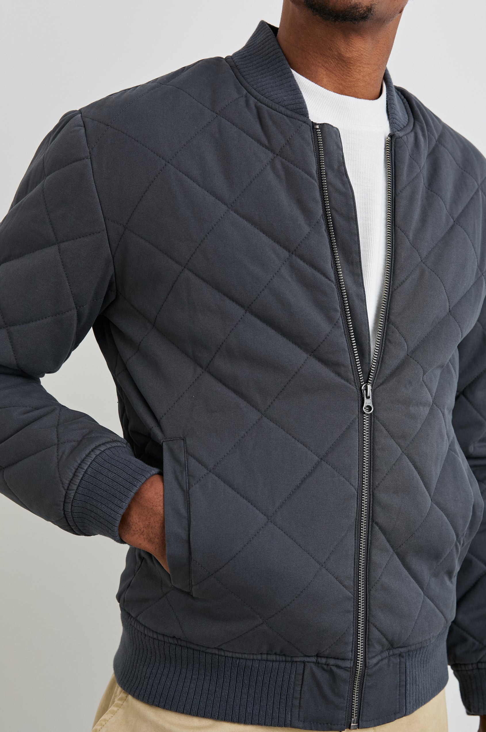 Peninsula Jacket with Zip Closure, Two Front Pockets, an Inner Zippered Pocket, a Quilted Pattern and Ribbed Trim in Obsidian Colorway - Front View Featured on Model