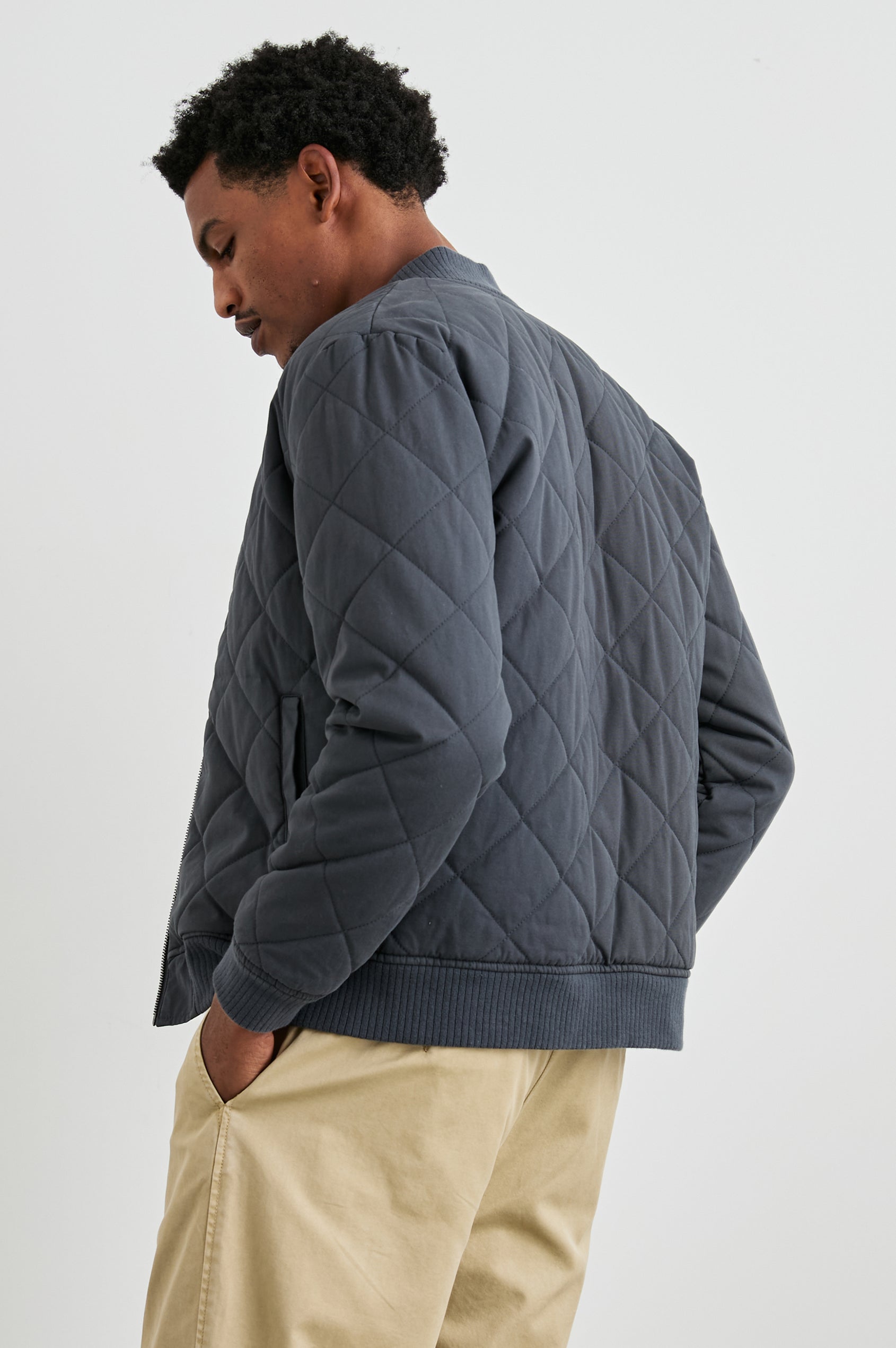 Peninsula Jacket with Zip Closure, Two Front Pockets, an Inner Zippered Pocket, a Quilted Pattern and Ribbed Trim in Obsidian Colorway - Back View Featured on Model