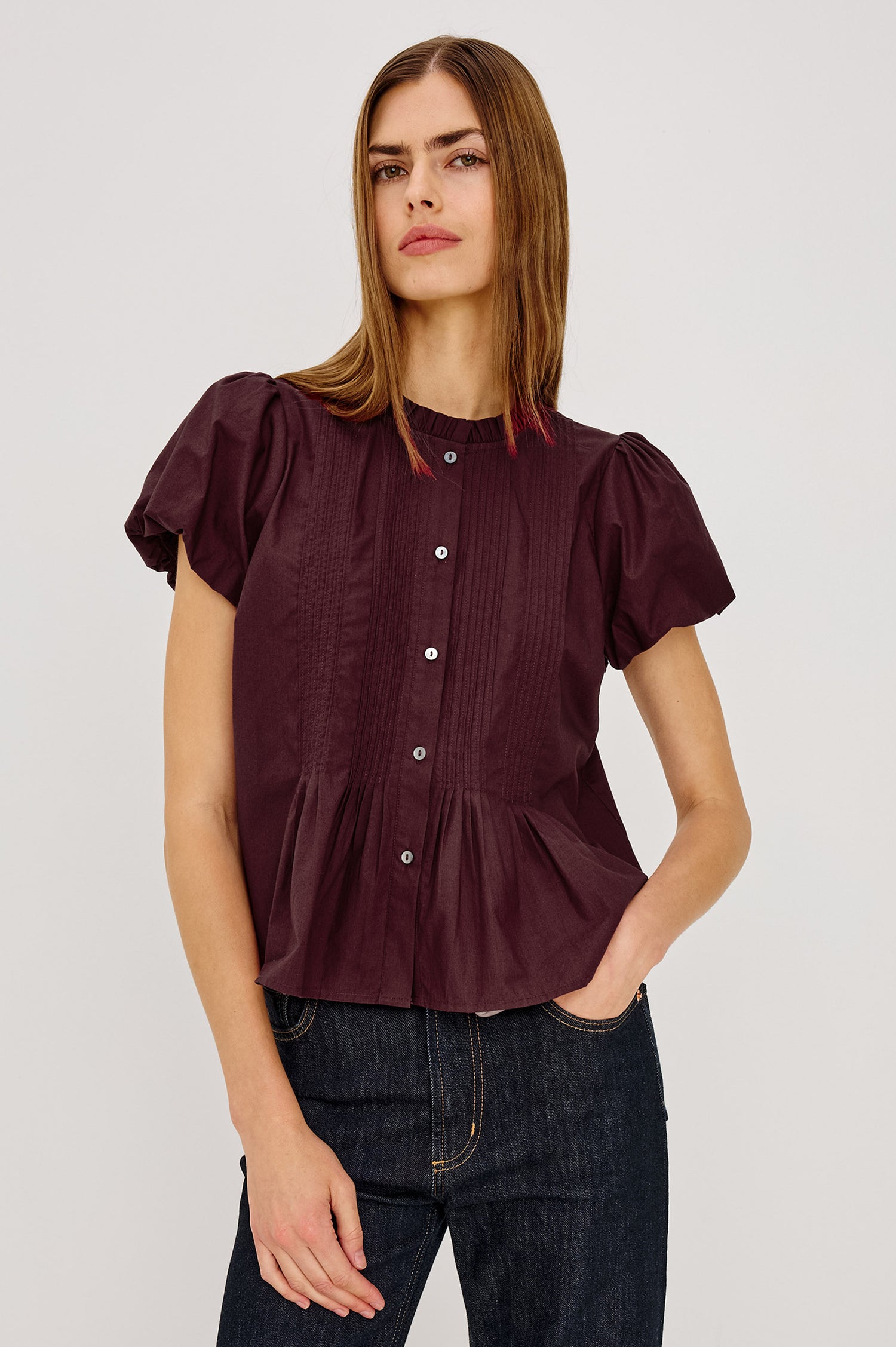 Pepper Shirt in Cotton Poplin With Loose Boxy Fit, Pintuck Detailing, Puff Cap Sleeves, Center-Front Buttons, and Soft Peplum Hem in Port Colorway - Upper Body Front View Featured on Model