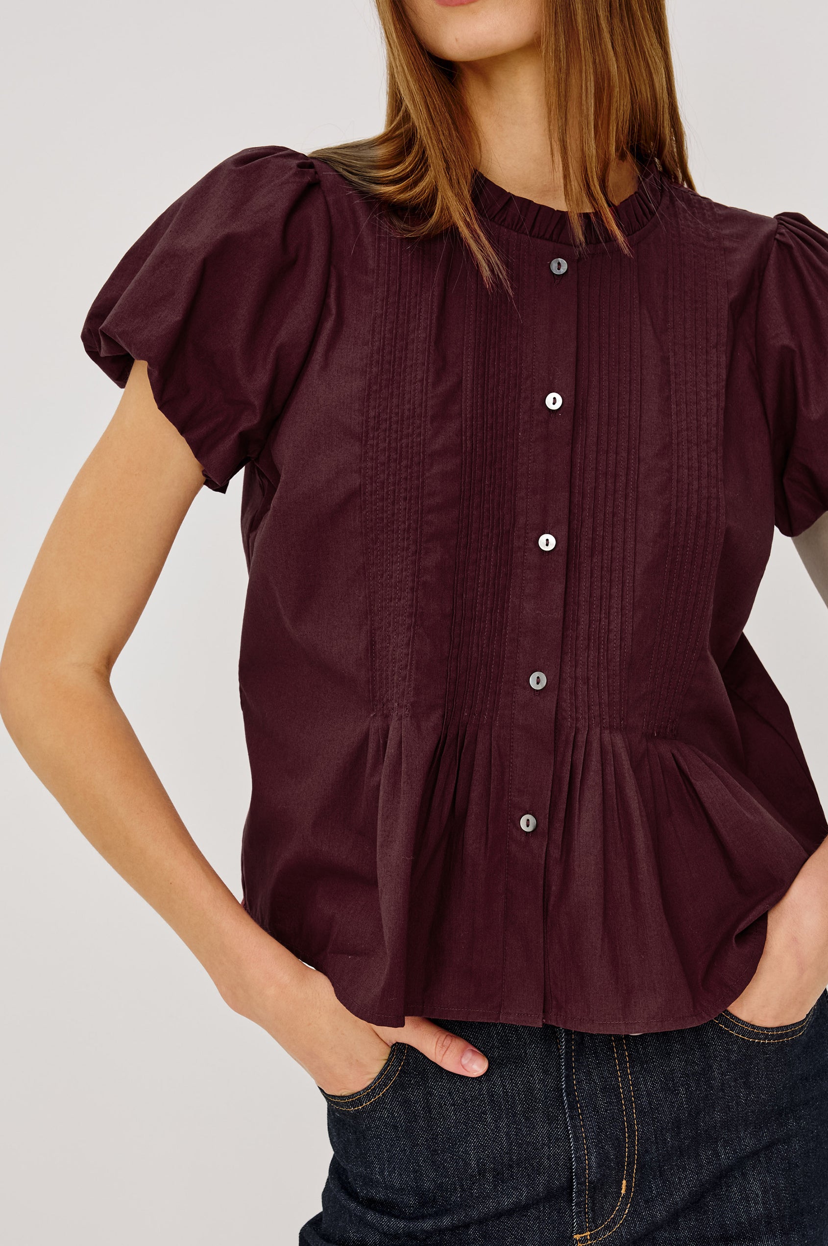 Pepper Shirt in Cotton Poplin With Loose Boxy Fit, Pintuck Detailing, Puff Cap Sleeves, Center-Front Buttons, and Soft Peplum Hem in Port Colorway - Upper Body Front View Featured on Model