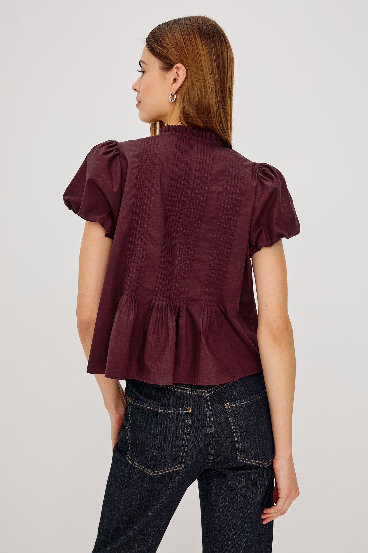 Pepper Shirt in Cotton Poplin With Loose Boxy Fit, Pintuck Detailing, Puff Cap Sleeves, Center-Front Buttons, and Soft Peplum Hem in Port Colorway - Upper Body Back View Featured on Model