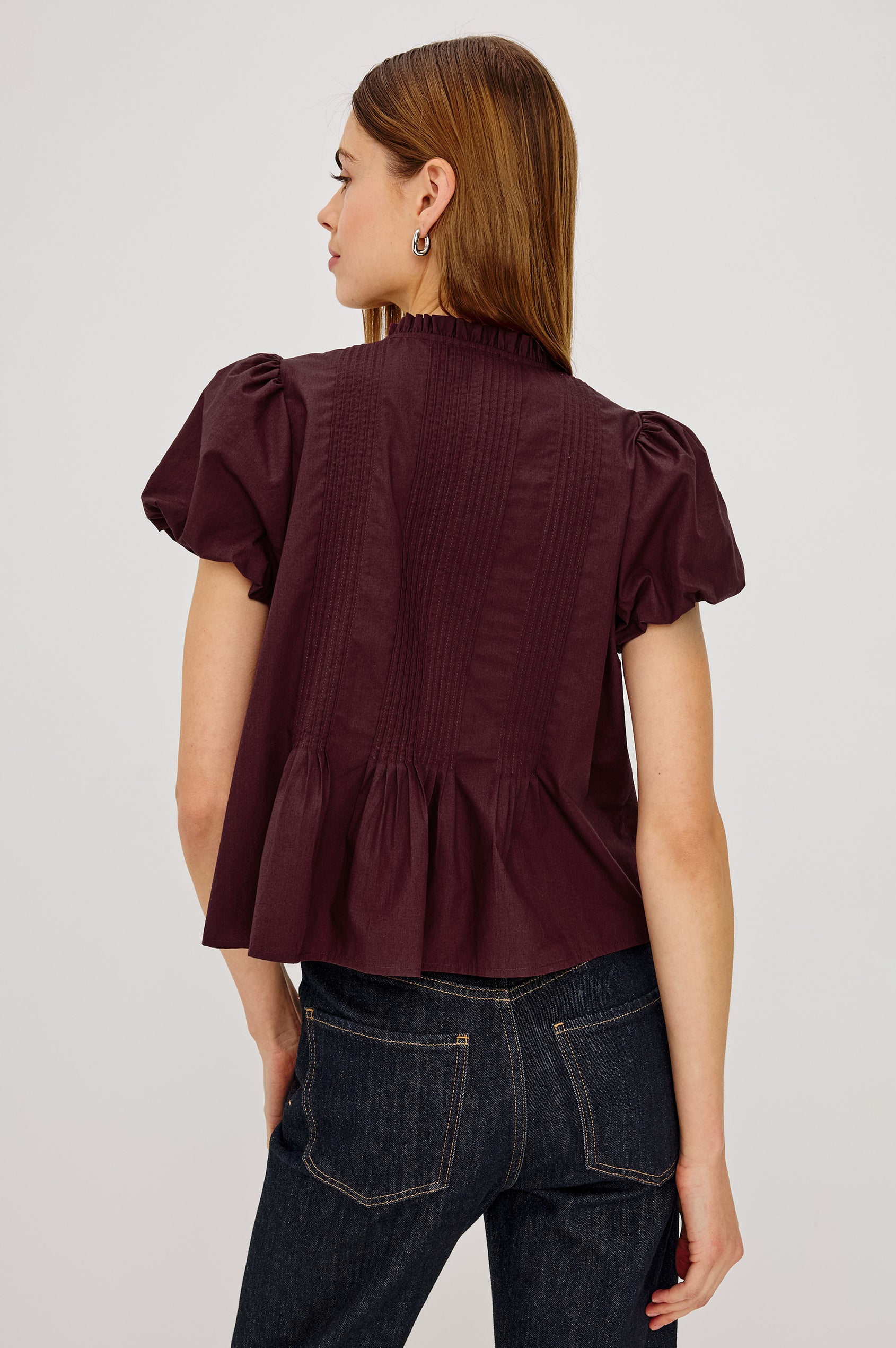 Pepper Shirt in Cotton Poplin With Loose Boxy Fit, Pintuck Detailing, Puff Cap Sleeves, Center-Front Buttons, and Soft Peplum Hem in Port Colorway - Upper Body Back View Featured on Model