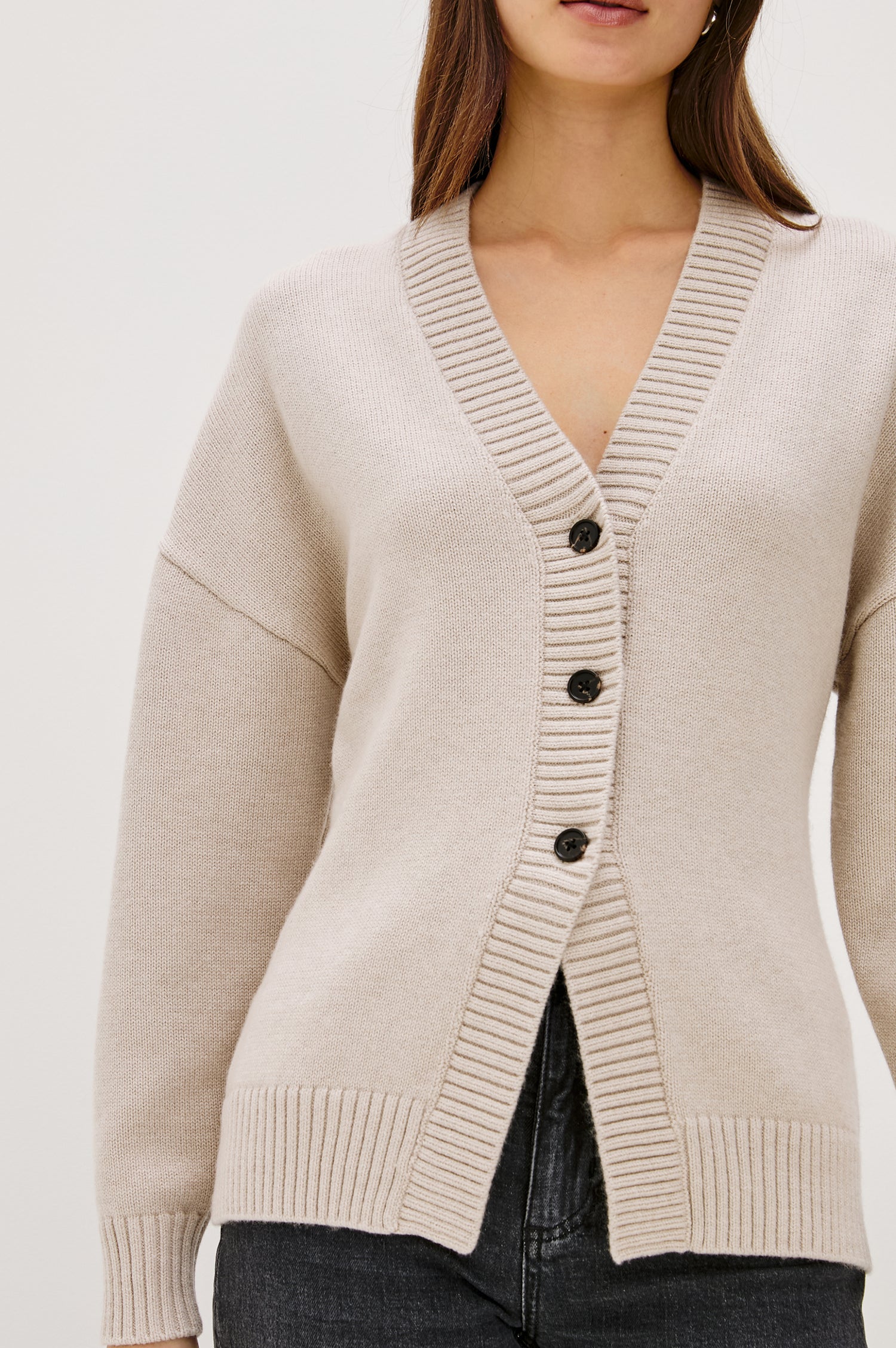 Longline cardigan in a cotton-wool blend in Taupe Colorway. The design features drop shoulders and a front cutaway detail, creating a soft, relaxed, and flattering silhouette. Close up View on Model.