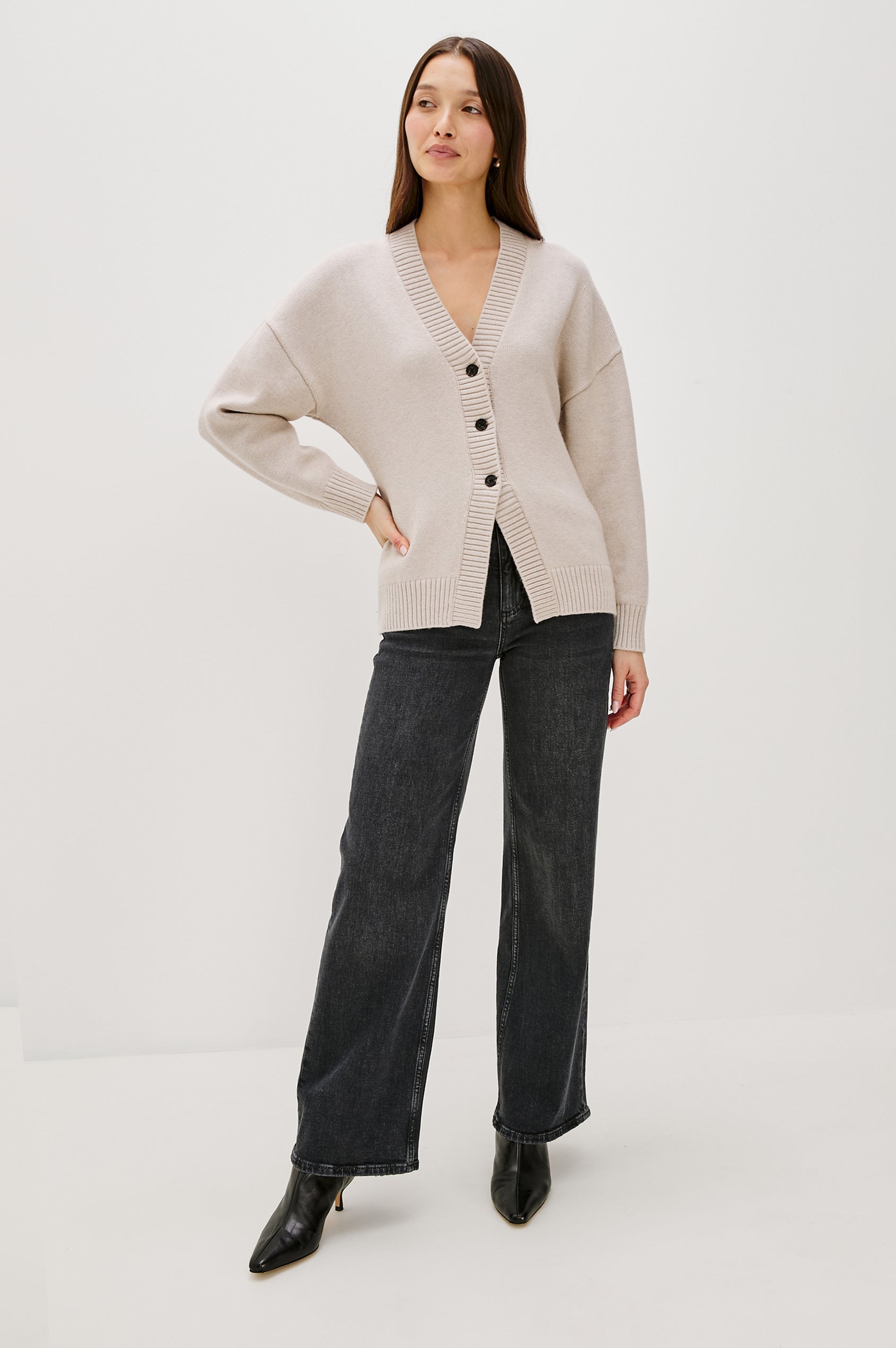 Longline cardigan in a cotton-wool blend in Taupe Colorway. The design features drop shoulders and a front cutaway detail, creating a soft, relaxed, and flattering silhouette. Full Body Front View on Model.