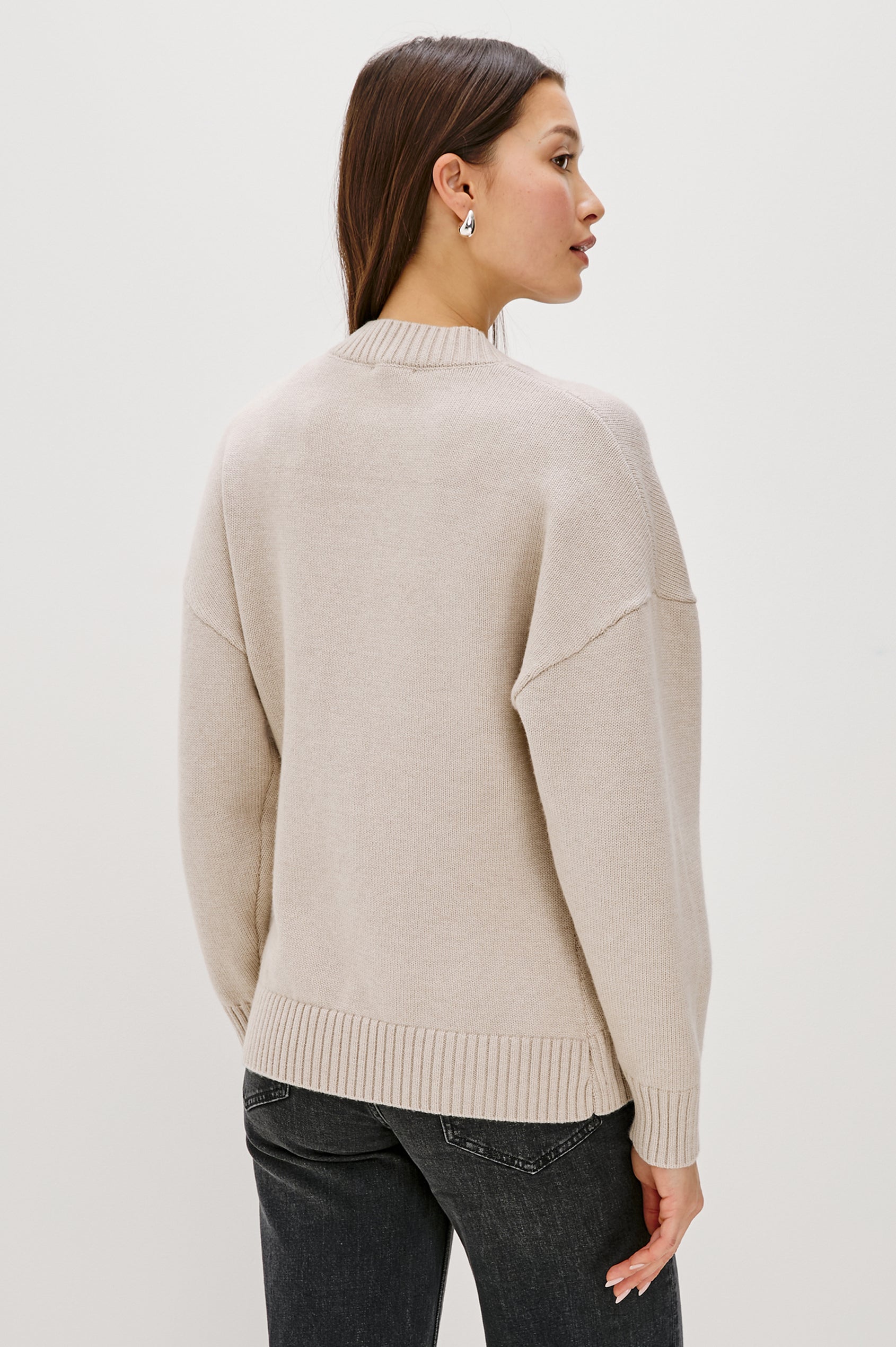 Longline cardigan in a cotton-wool blend in Taupe Colorway. The design features drop shoulders and a front cutaway detail, creating a soft, relaxed, and flattering silhouette. Back View on Model.