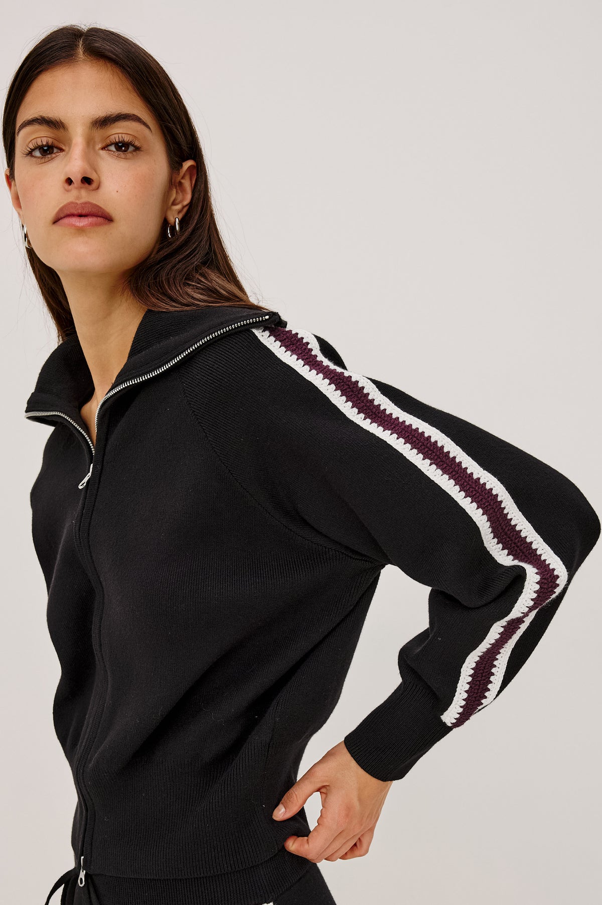 Piper Track Sweater Jacket in Cotton-Blend Knit With Shawl Collar, Double-Zip Front, and Contrast Crochet Stripes Down Long Sleeves in Black Merlot Stripe Colorway - Upper Body Front Detail View Featured on Model.