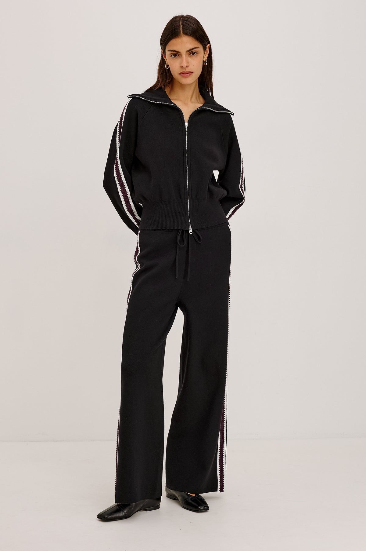 Piper Track Sweater Jacket in Cotton-Blend Knit With Shawl Collar, Double-Zip Front, and Contrast Crochet Stripes Down Long Sleeves in Black Merlot Stripe Colorway - Full Body Front View Featured on Model.