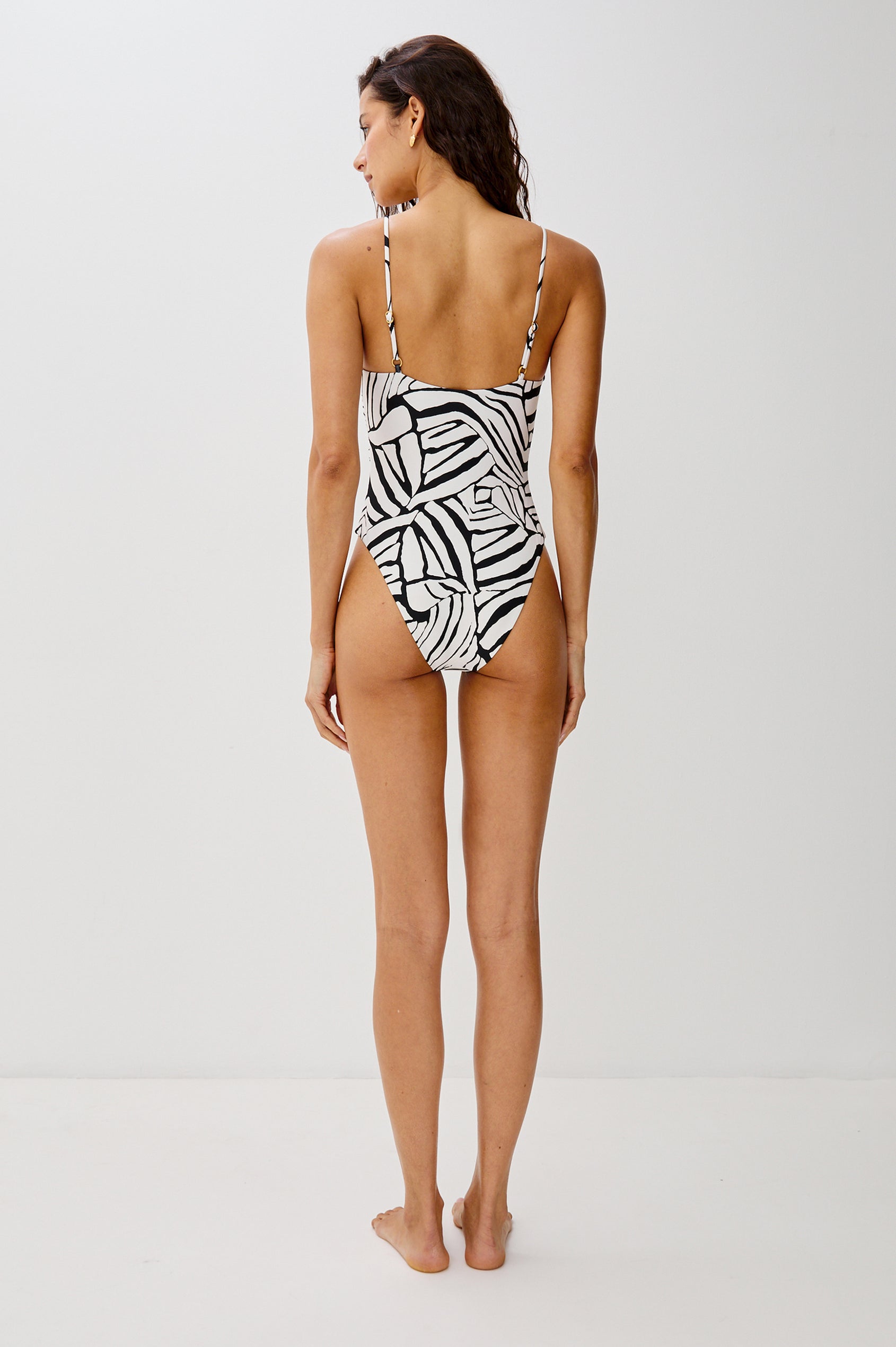 Piper Classic Coverage One Piece Bathing Suit with Adjustable Spaghetti Straps, Low V-Neck, Tie At Bust, Keyhole Cutout At Bust in Black and White Abstract Playa Blanca Colorway. Full Body Back View Shown on Model.