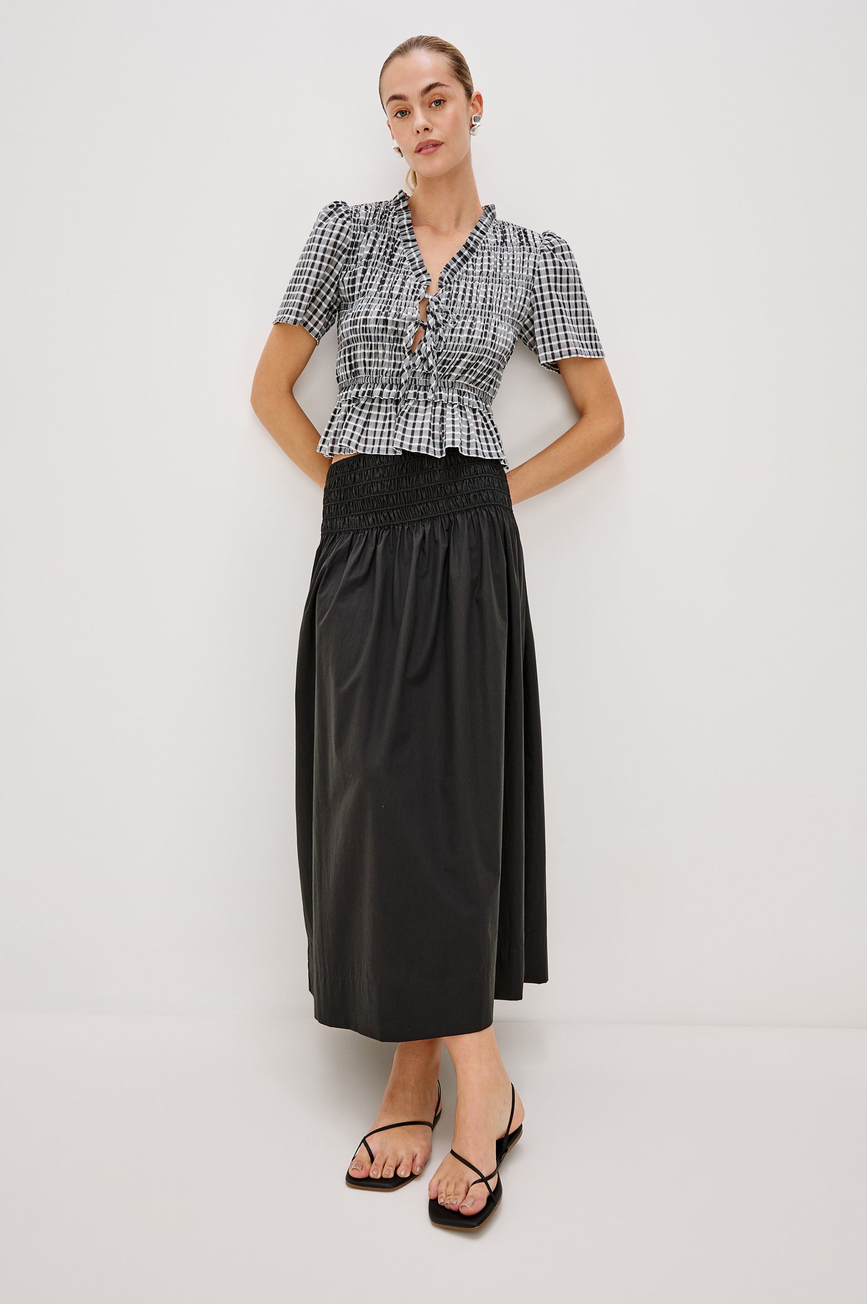 Portia V-Neck Tie Front Top with Short Puff Sleeves and a Ruffled Peplum Hem in Ash Seersucker Colorway. Full Body Front View Shown on Model.