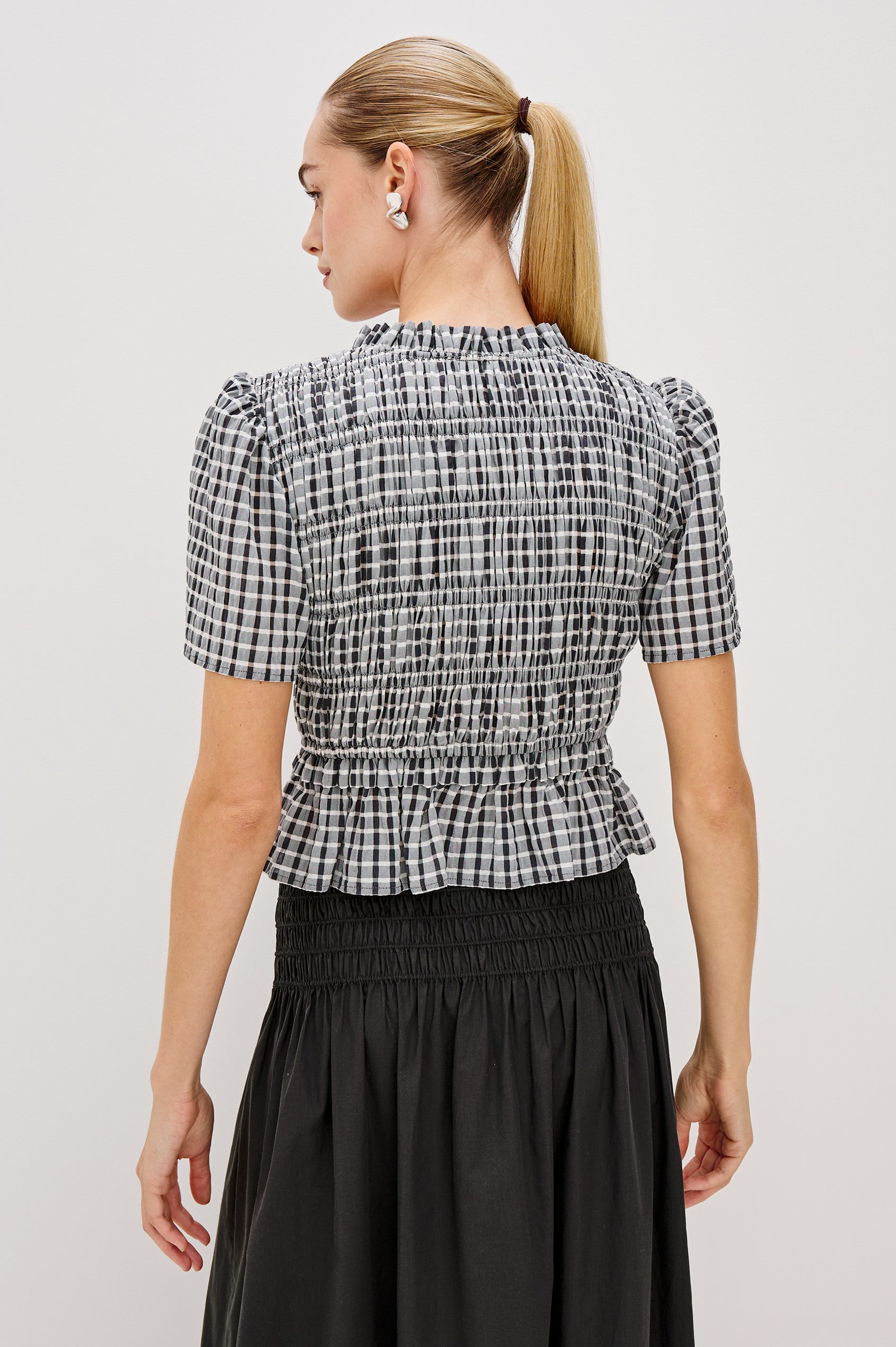 Portia V-Neck Tie Front Top with Short Puff Sleeves and a Ruffled Peplum Hem in Ash Seersucker Colorway. Back View Shown on Model.