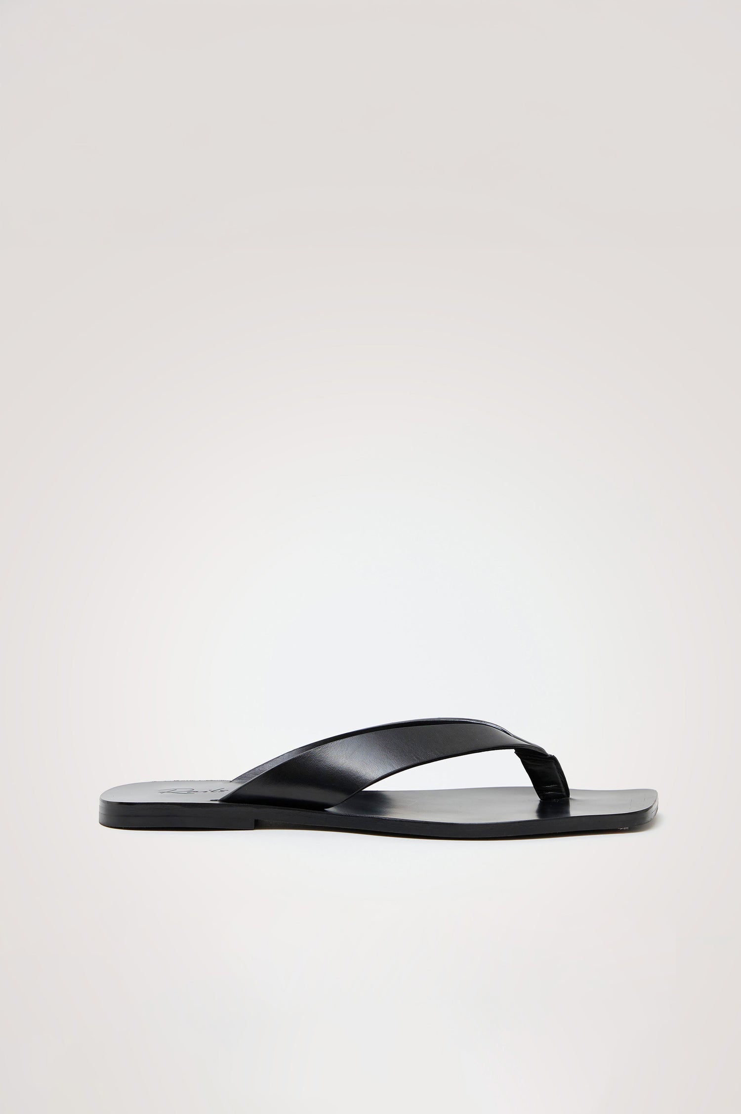 Porto Thong Sandal in Leather With Square Toe and Cushioned Footbed With Branded Embossed Detail in Black Colorway - Front View Featured on Model