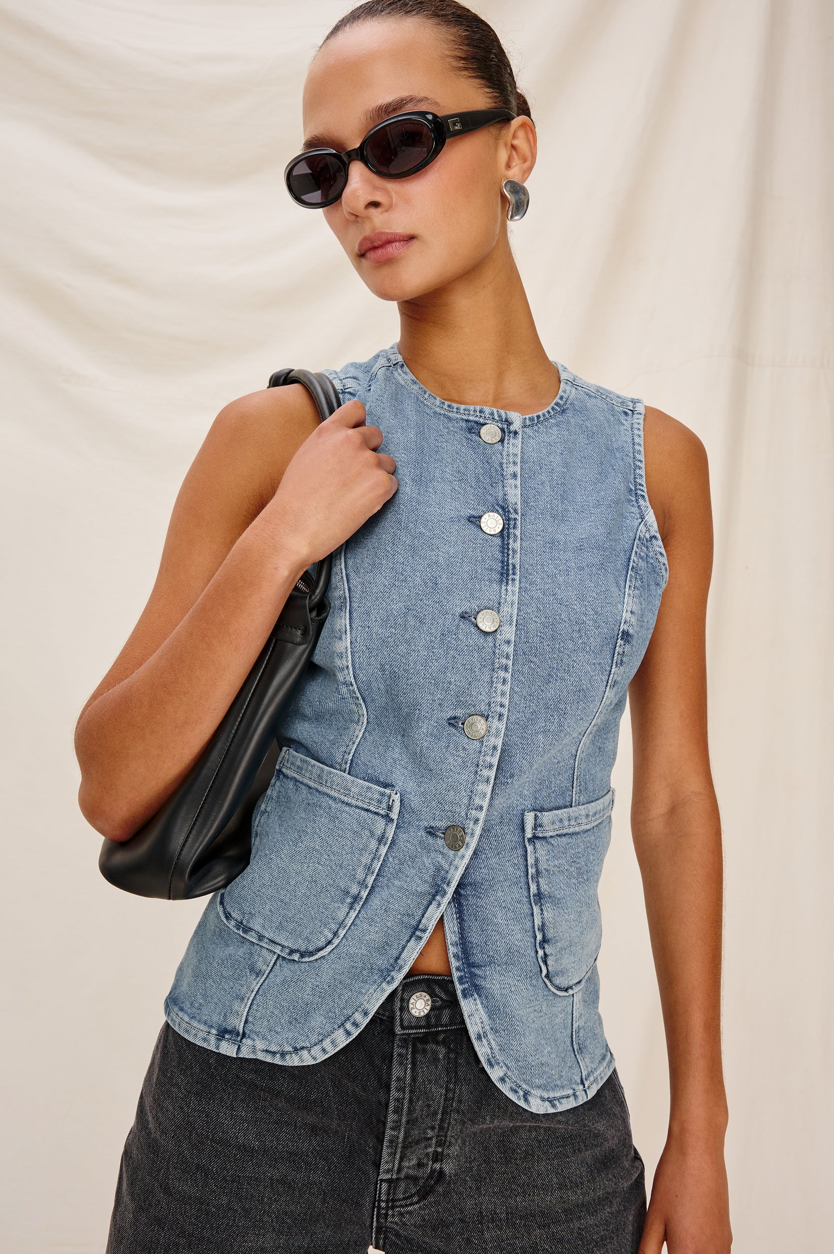 Portola Sleeveless Denim Vest with Exposed Button Front Closure, Crew Neck, Front Patch Pockets and a Scalloped Split Hem in Blue Eyed Girl Colorway. Full Body Front View Shown on Model.