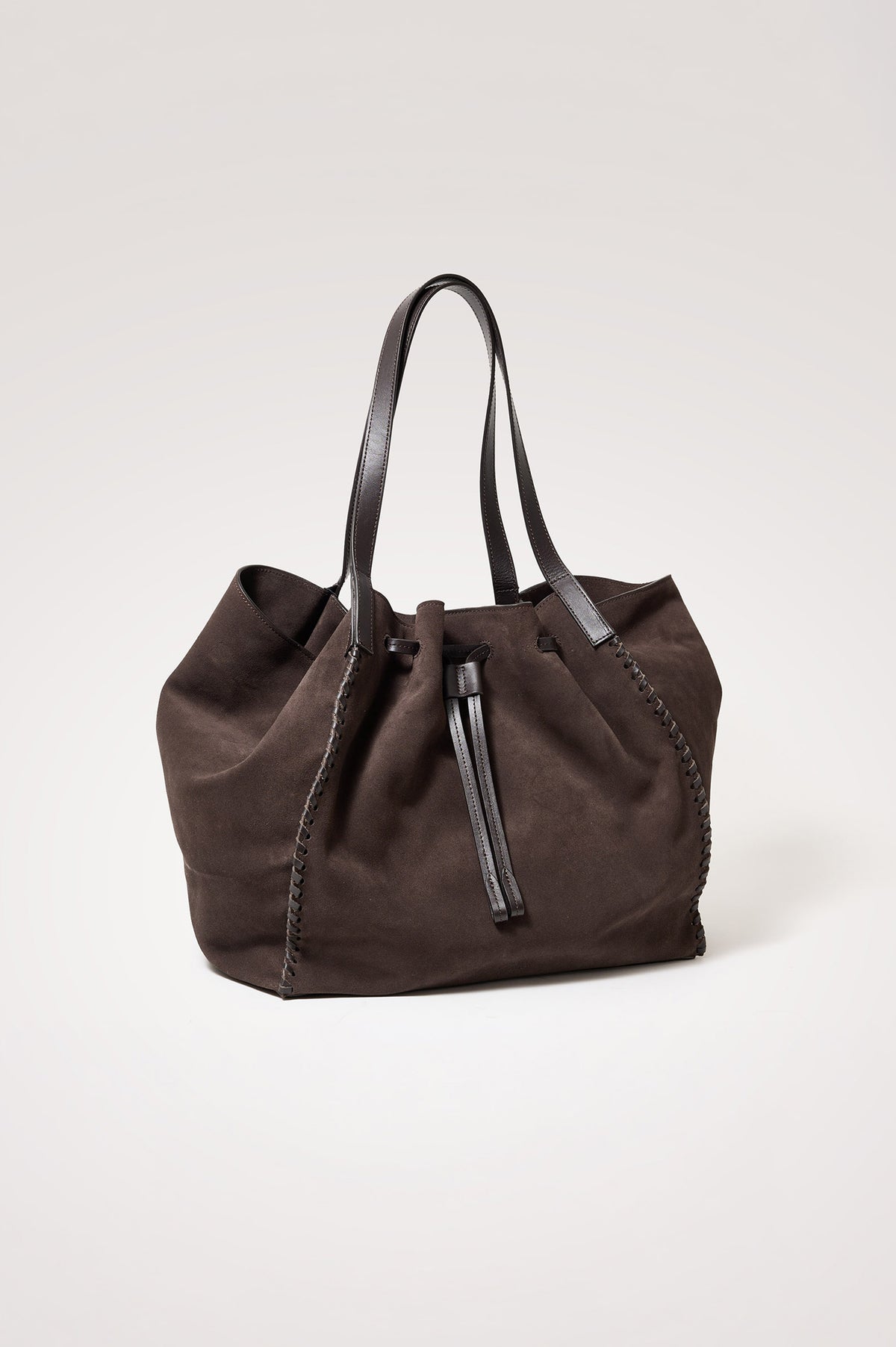 Prato Bucket Tote in Suede With Whipstitch Trim, Fixed Top Straps, Drawcord Closure, Interior Zip Pocket, Interior Slip Pocket in Dark Brown Suede Colorway - Front Product View Featured