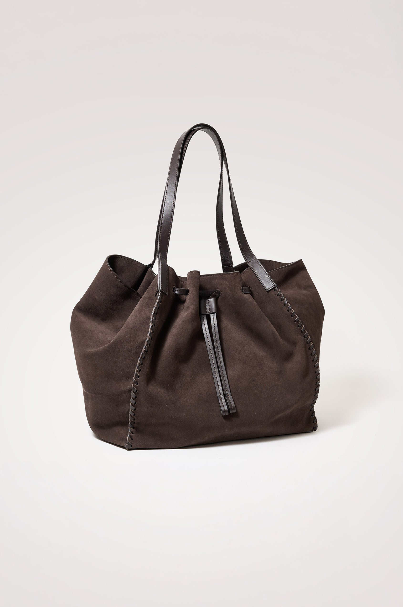 Prato Bucket Tote in Suede With Whipstitch Trim, Fixed Top Straps, Drawcord Closure, Interior Zip Pocket, Interior Slip Pocket in Dark Brown Suede Colorway - Front Product View Featured