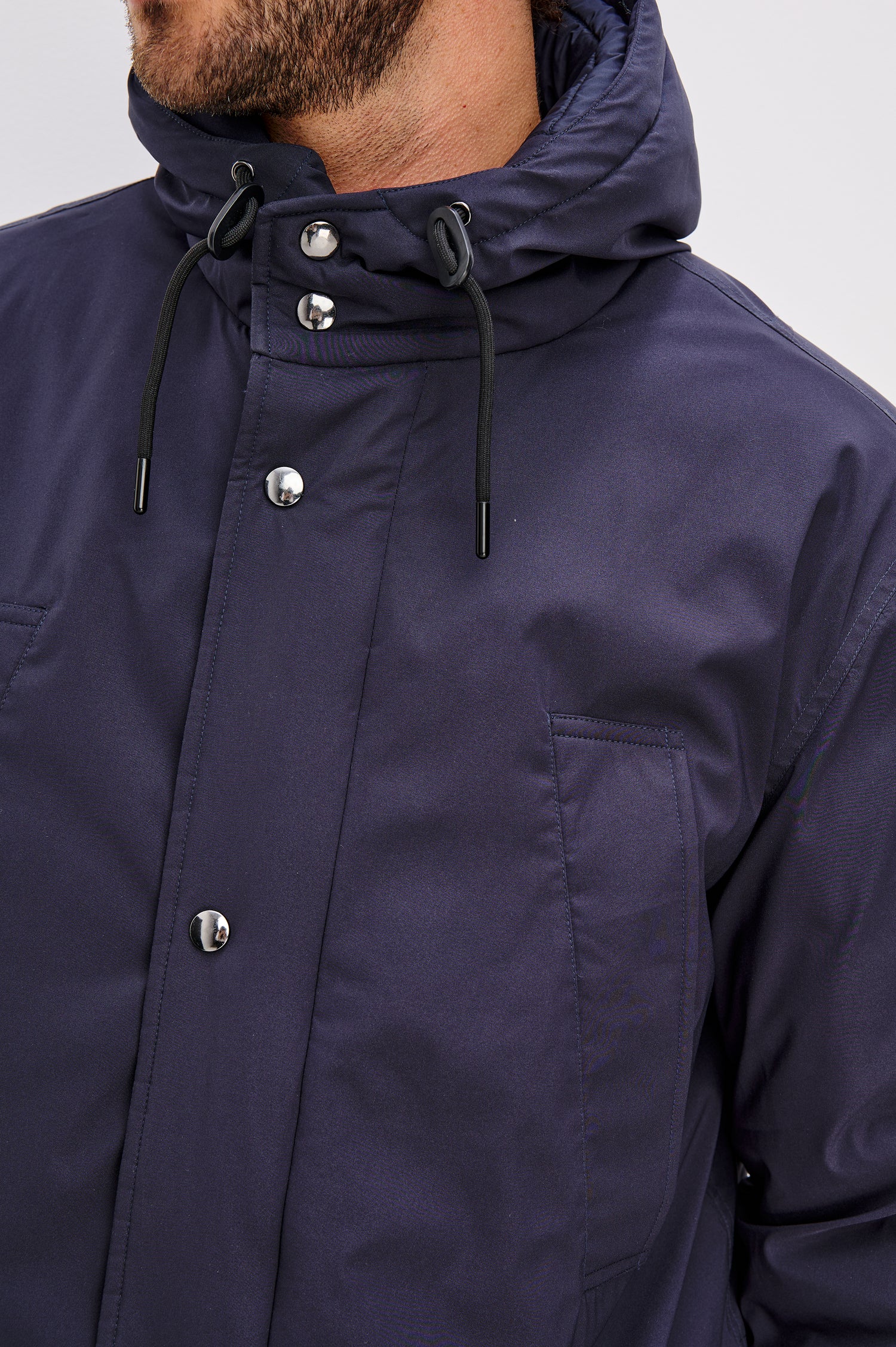 Rainier Parka Coat With Drawcord Hood in Water-Resistant Nylon, Side Snap Button Pockets, Double Front Snap Flap, and Back Seam Vent in Navy Colorway - Upper Body Front Close Up View Featured on Model