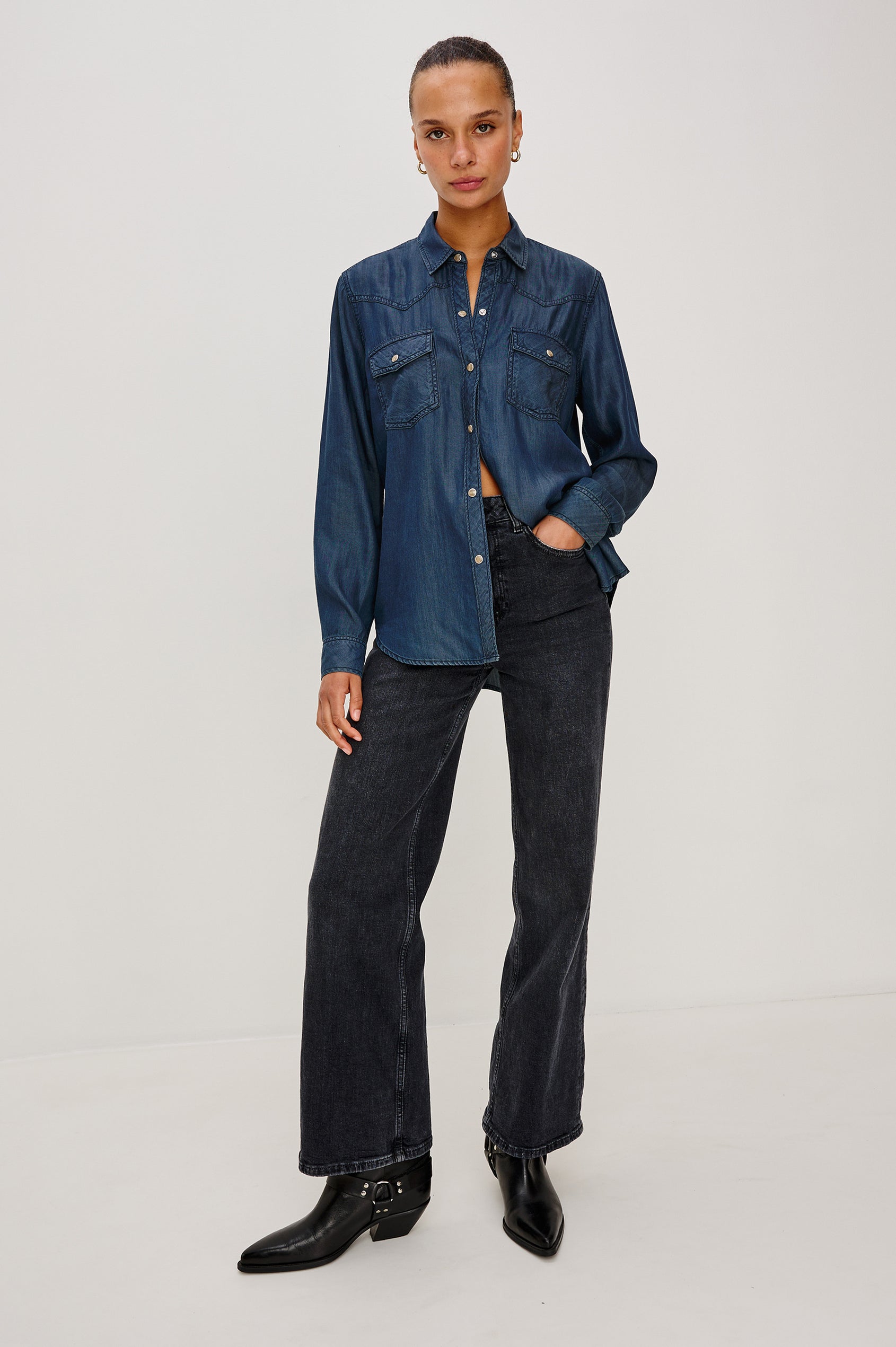 Remi is a utility-style Tencel denim shirt with a relaxed fit. The shirt features a notched collar, two front flap pockets, and faux horn buttons etched with a logo in Oceana dark blue colorway - Full Body Front View featured on model