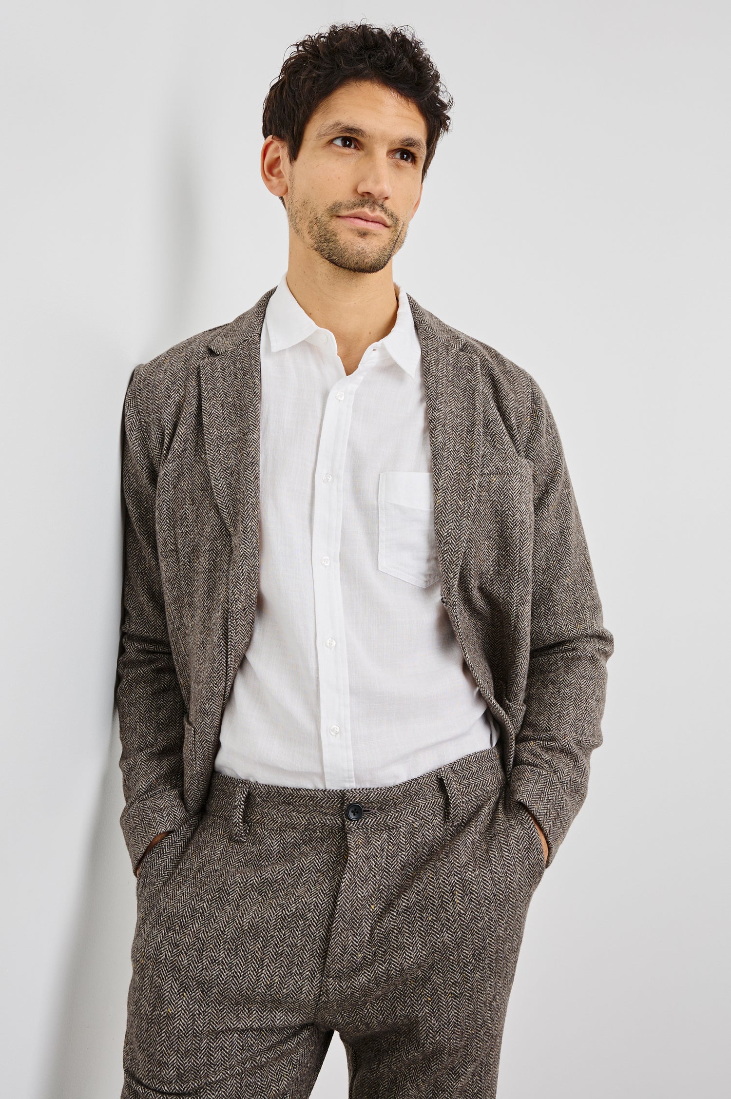 Reynard Blazer with Two Button Closure, Two Front Pockets, a Chest Welt Pocket, Herringbone Fabric in Highland Tweed Colorway, a Brown - Front View Featured on Model