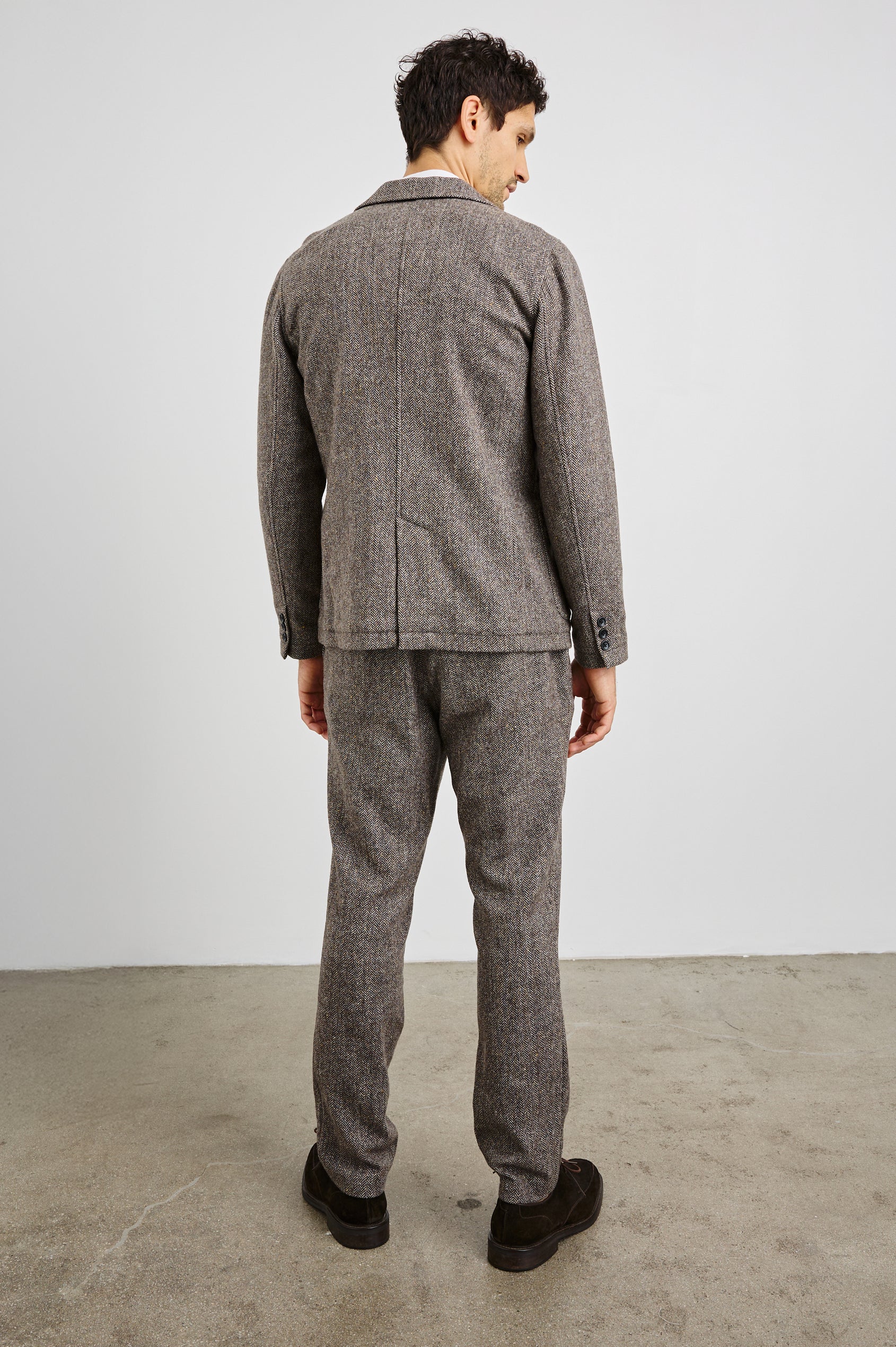 Reynard Blazer with Two Button Closure, Two Front Pockets, a Chest Welt Pocket, Herringbone Fabric in Highland Tweed Colorway, a Brown - Back Full Body View Featured on Model