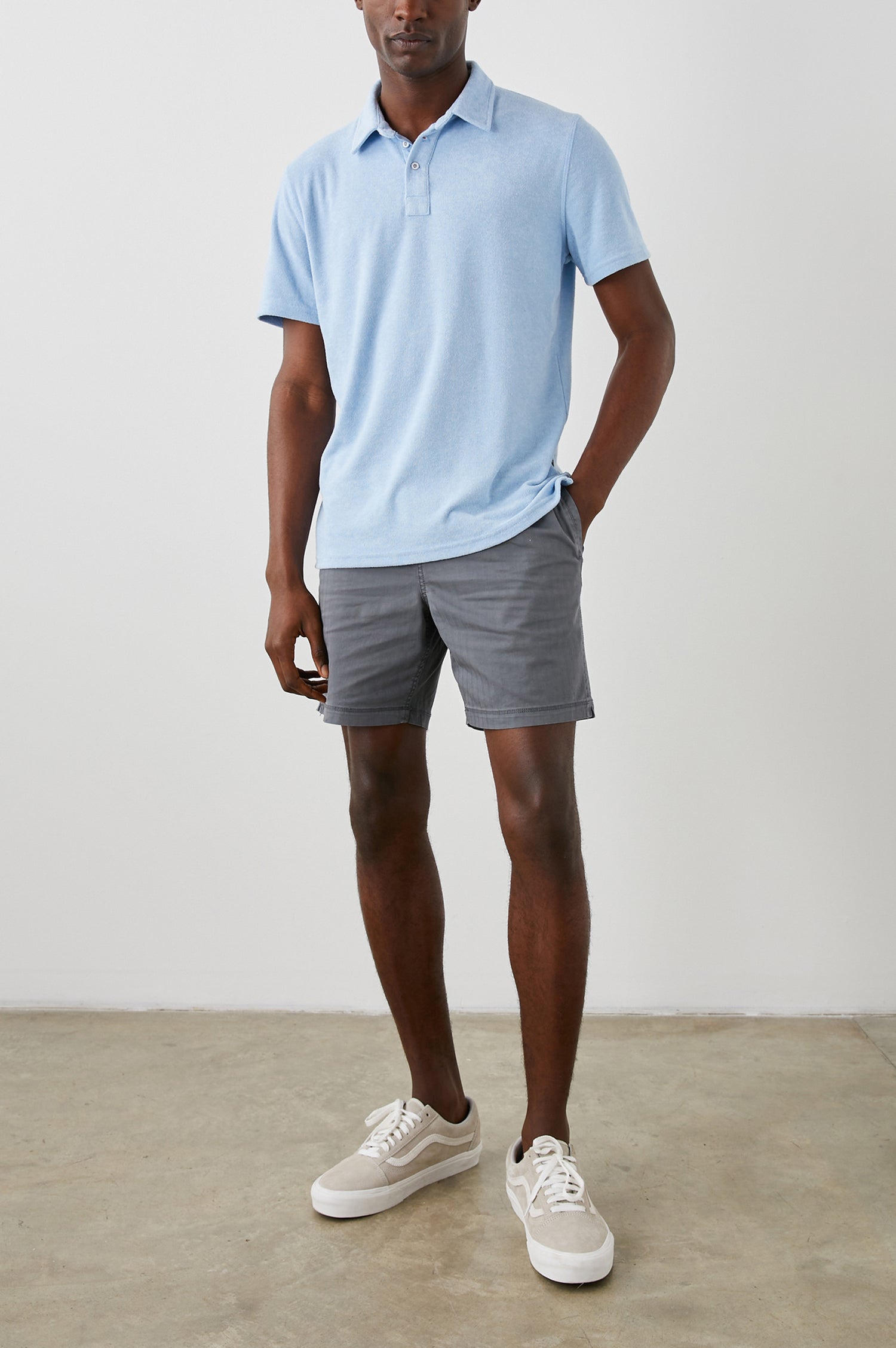 Rhen Short-Sleeve Polo Shirt with a Three-Button Placket in Terry Chambray Blue Colorway - Front Full Body View Featured on Model