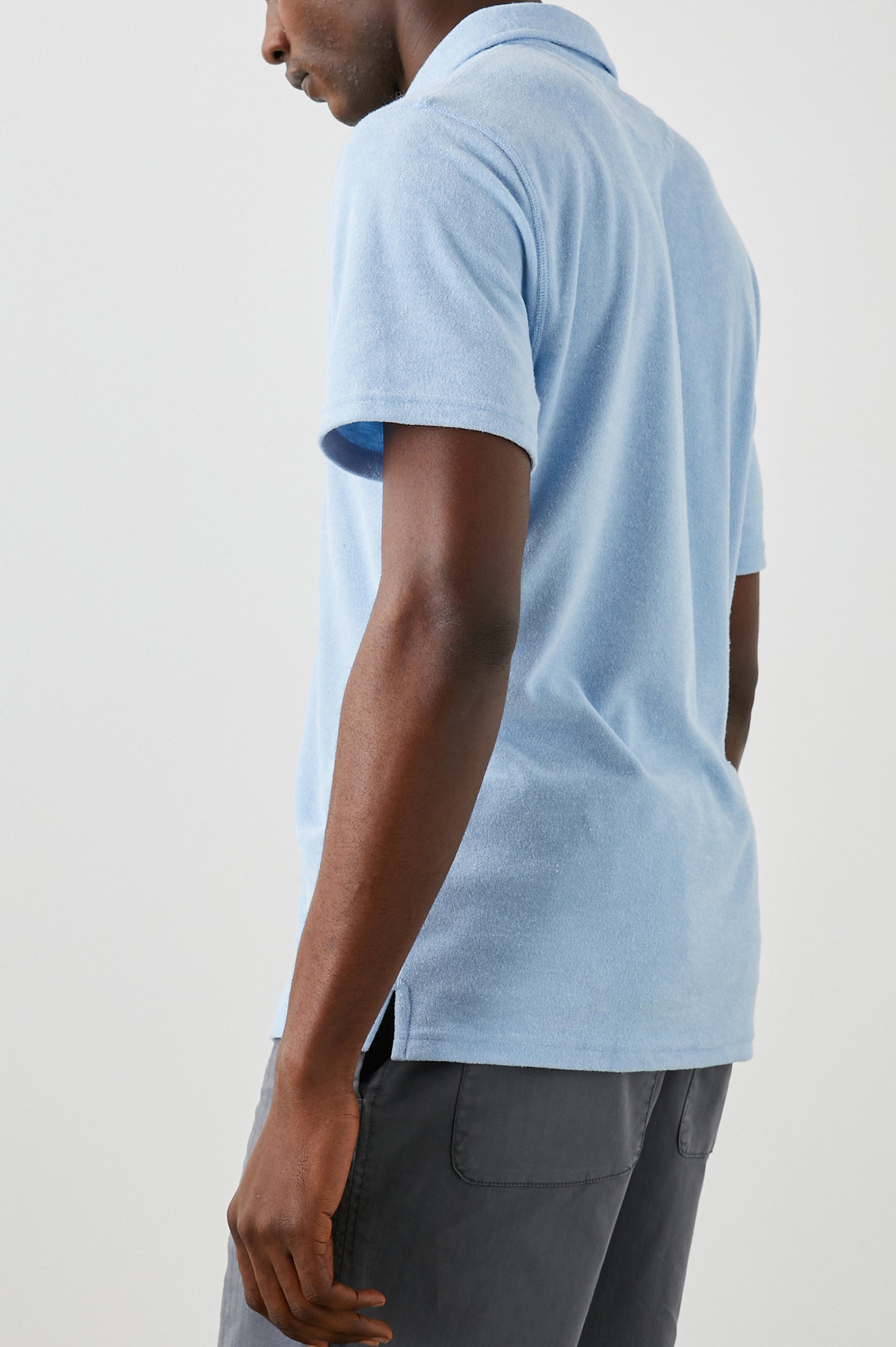 Rhen Short-Sleeve Polo Shirt with a Three-Button Placket in Terry Chambray Blue Colorway - Back View Featured on Model