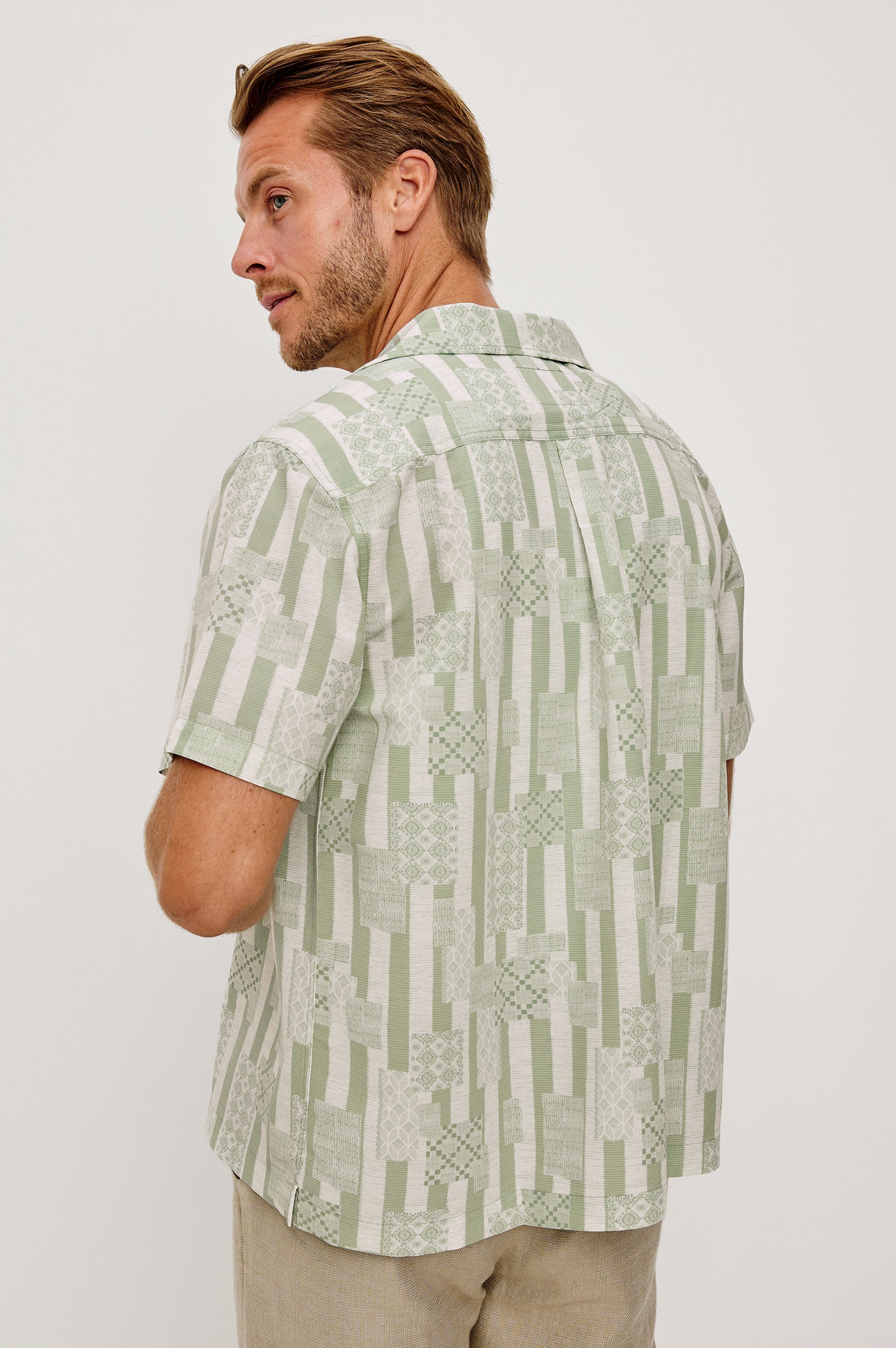 Rhodes Boxy Button-Up Shirt in Crepe With Back Box Pleat, Vintage-Inspired Notched Collar, Front Buttons, and Short Sleeves in Patchwork Stripe Sage Colorway - Upper Body Back View Featured on Model