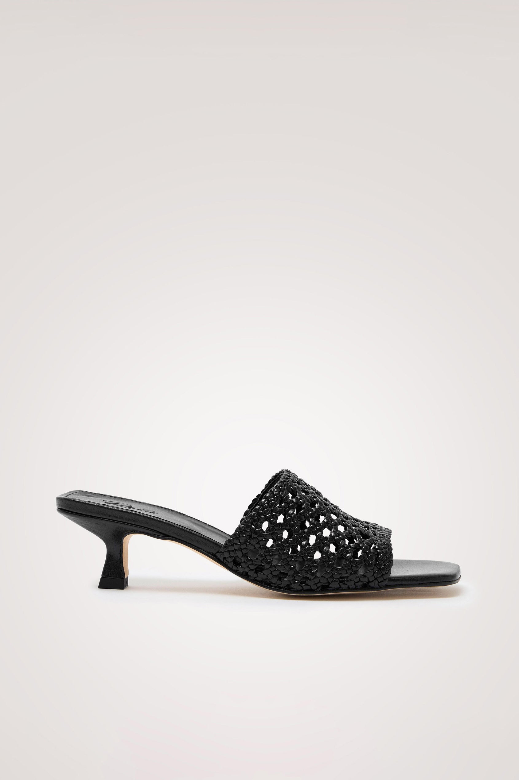 Rimini Mule Heel in Leather With Woven Upper, Square Toe, and Cushioned Footbed With Branded Embossed Detail in Black Colorway - Side View Featured