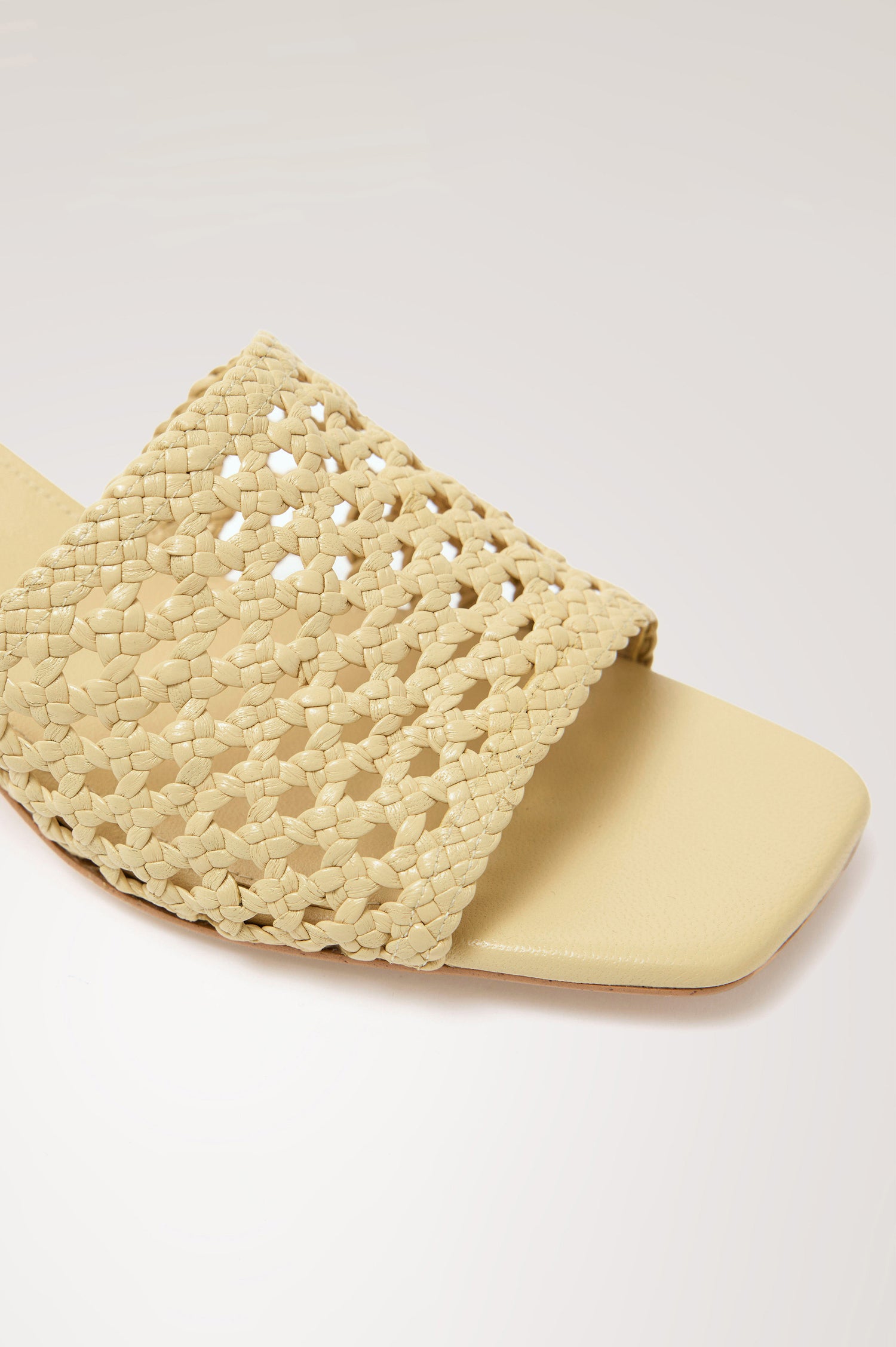 Rimini Mule Heel in Leather With Woven Upper, Square Toe, and Cushioned Footbed With Branded Embossed Detail in Butter Yellow Colorway - Close up View Featured