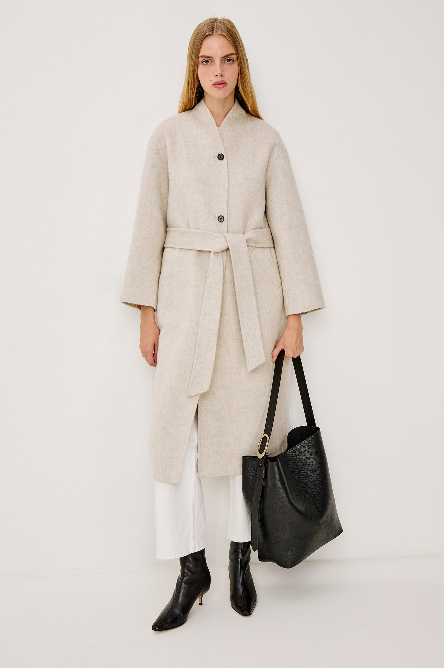 Roland Longline Coat in Wool Blend and Relaxed Fit With Slight Stand Collar, Front Buttons, Long Sleeves, Side Pockets, and an Adjustable Waist Belt in Oatmeal Colorway - Full Body Front View Featured on Model
