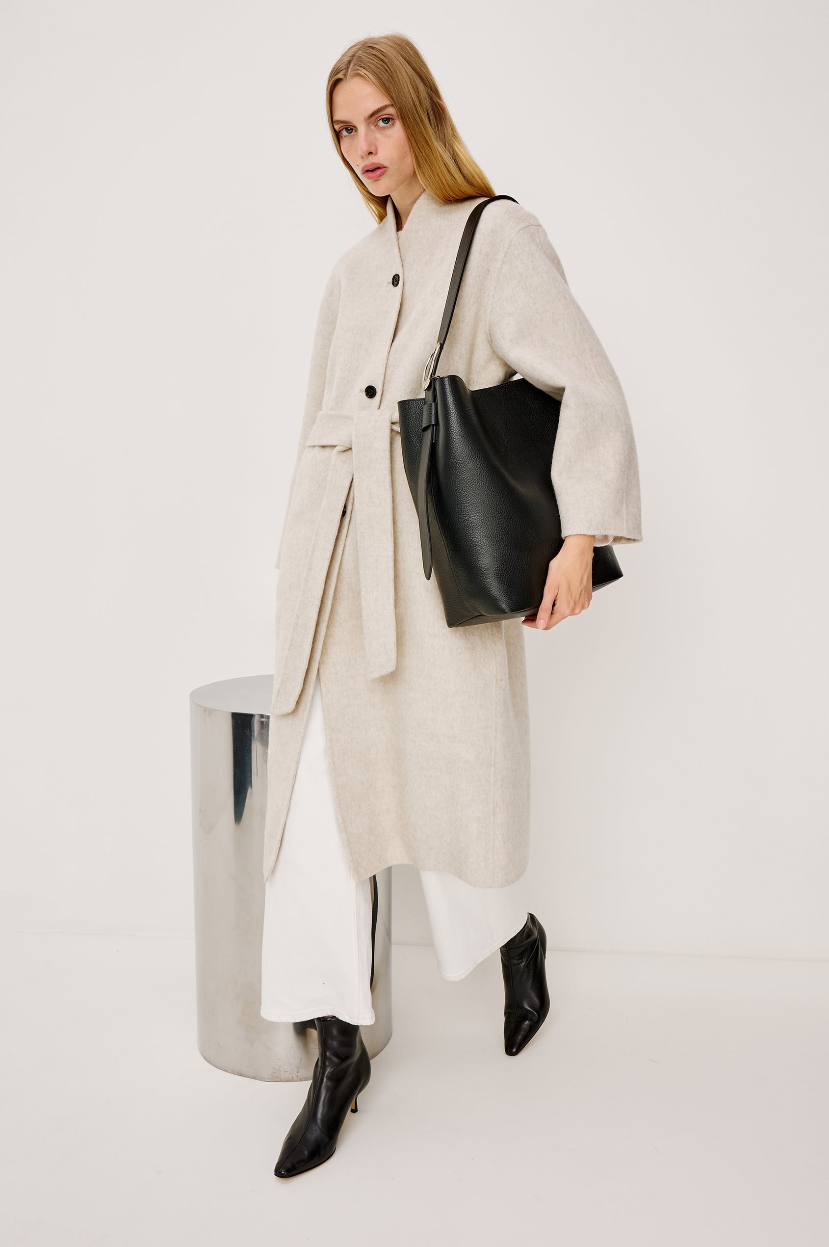 Roland Longline Coat in Wool Blend and Relaxed Fit With Slight Stand Collar, Front Buttons, Long Sleeves, Side Pockets, and an Adjustable Waist Belt in Oatmeal Colorway - Full Body Side View Featured on Model Walking