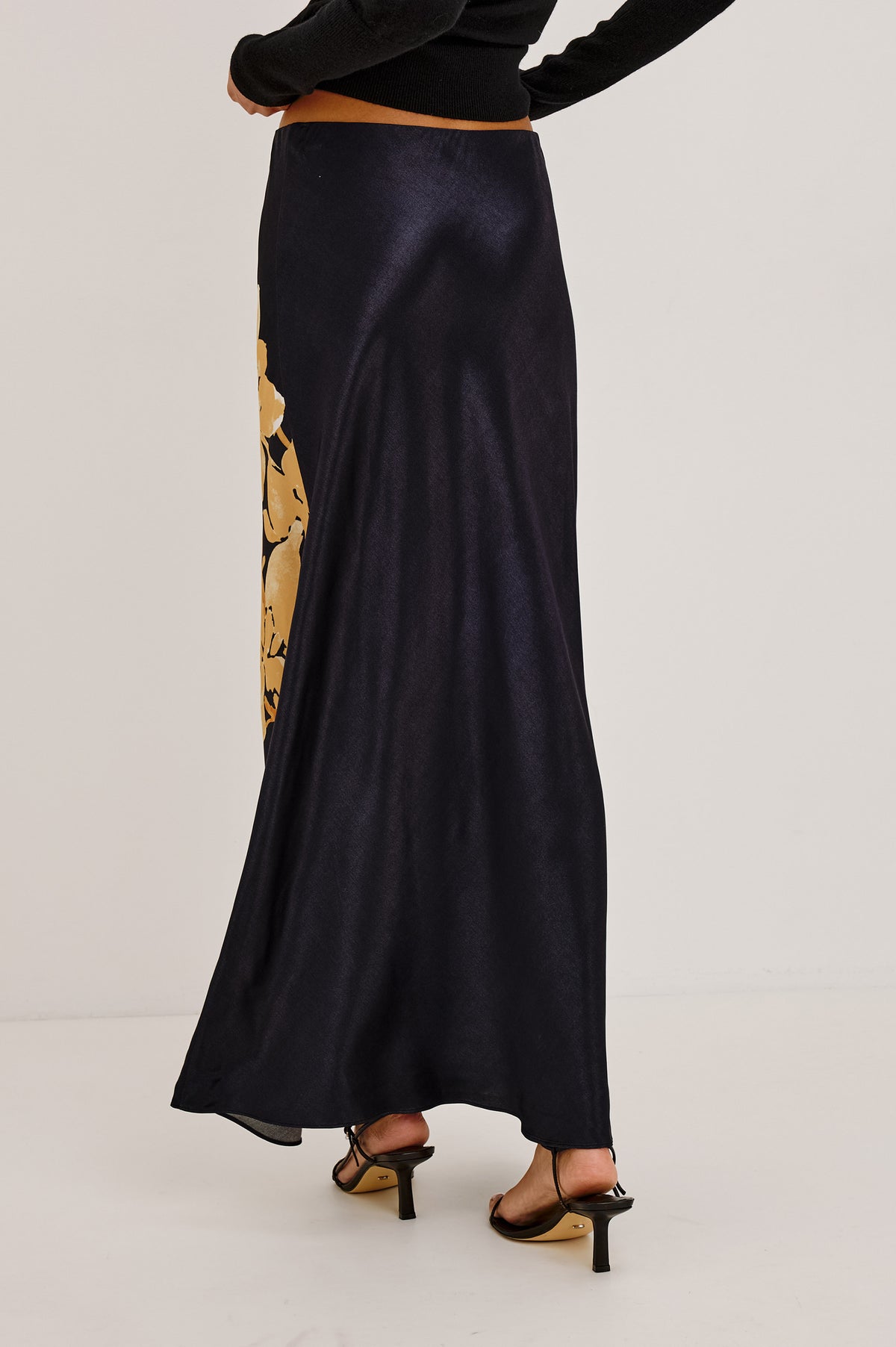 Romina Skirt in Satin With Floral Placement Print, Bias Cut, and Maxi Length in Gold Lily Colorway - Upper Body Back View Featured on Model.