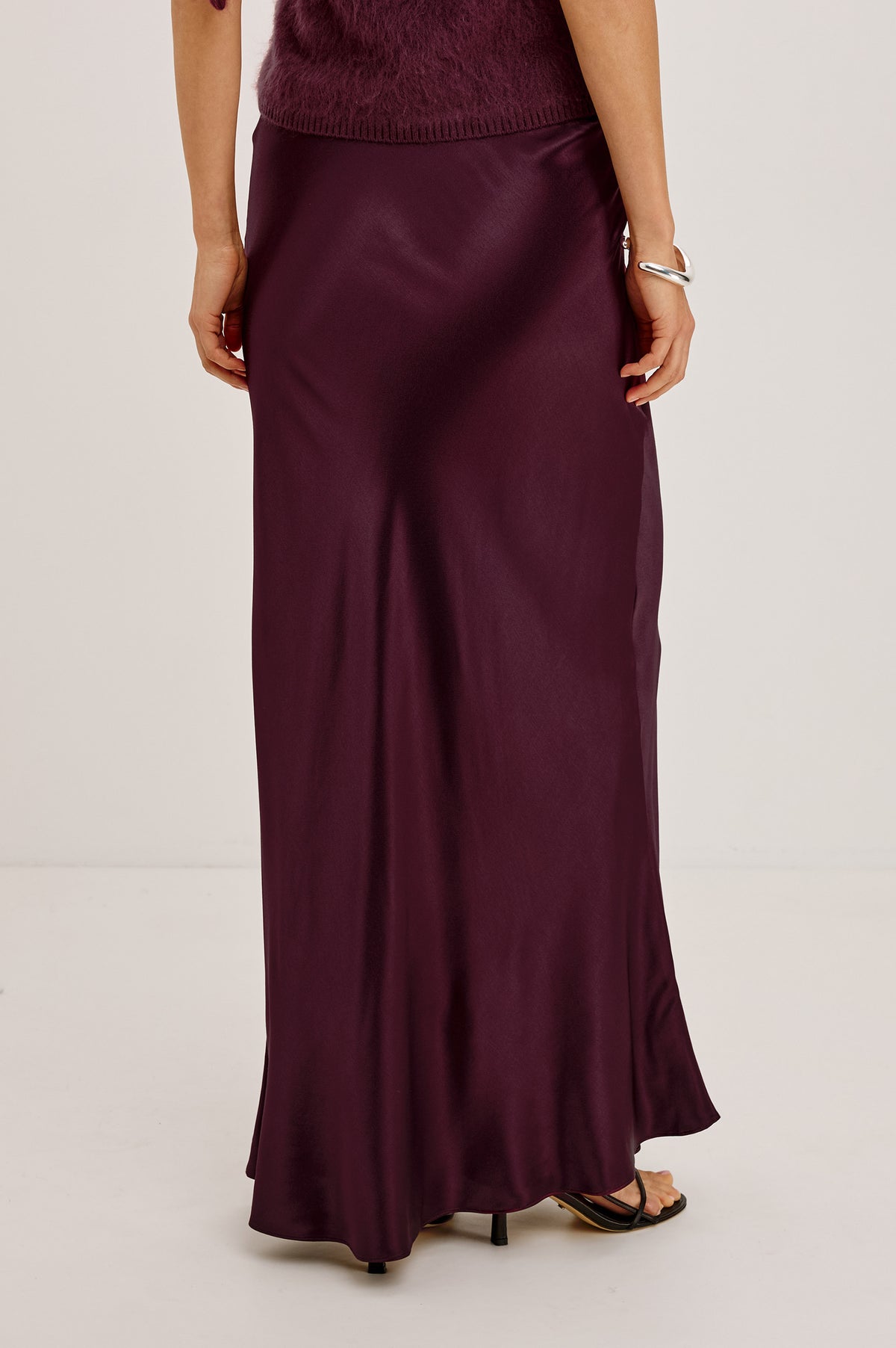 Romina Maxi Skirt Bias Cut in Satin-Back Crepe With Elastic High Waist in Wine Colorway - Upper Body Back View Featured on Model.