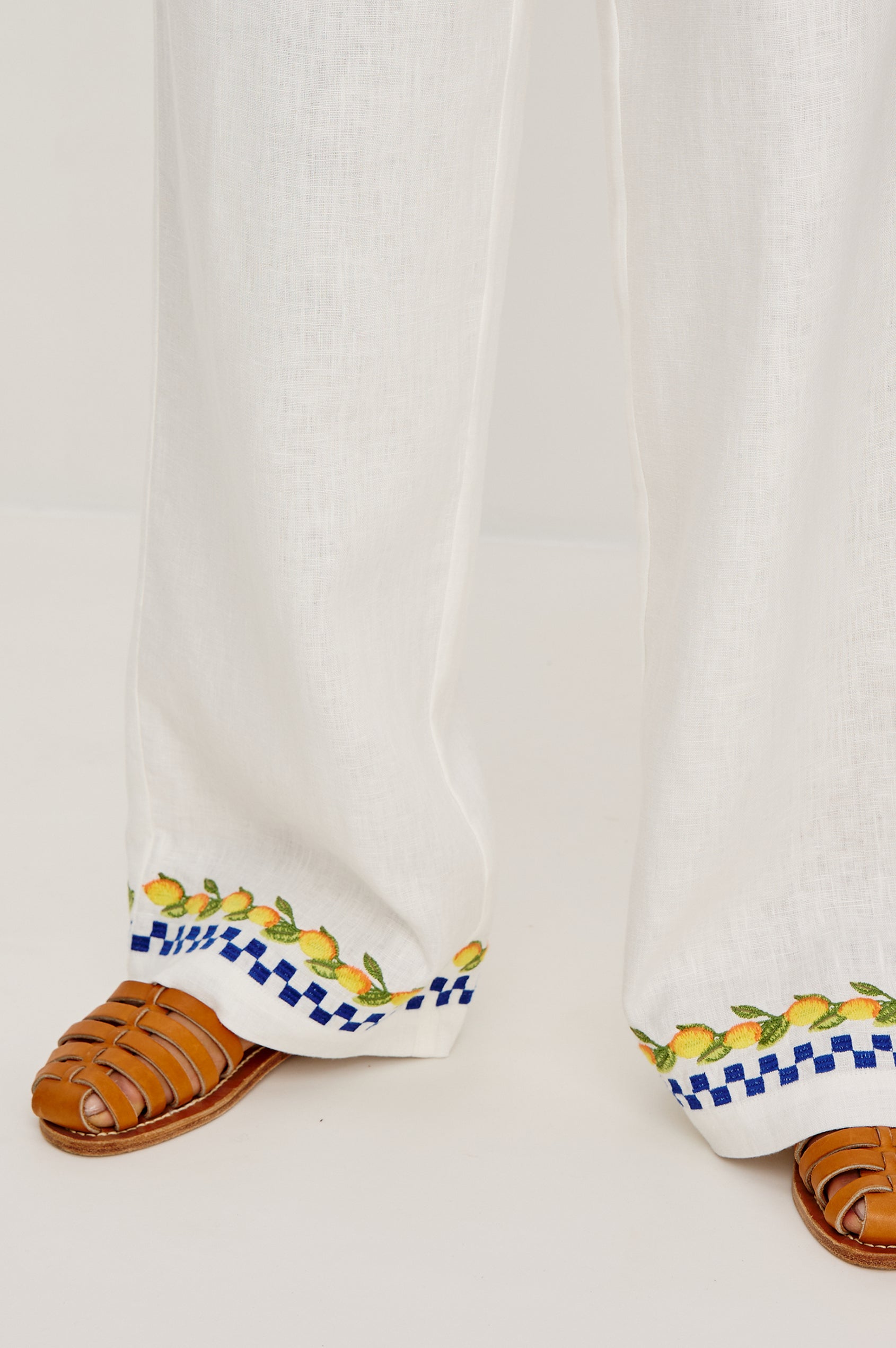 Rosita linen pant in Sorrento Embroidery colorway featuring side pockets, drawstring waist, and Italian inspired embroidery - close up of details on model