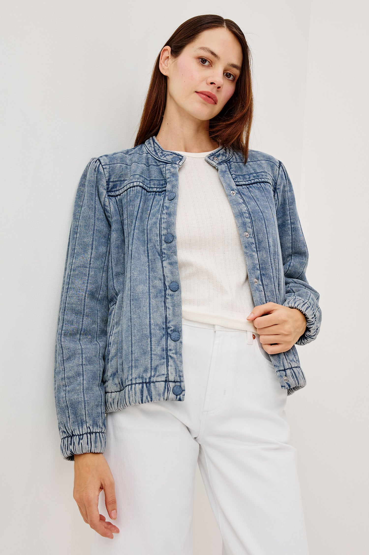 The Rosell is a boxy bomber jacket in ultra-soft quilted washed denim with snap button closures, elastic cuffs and hem, and long puff sleeves.