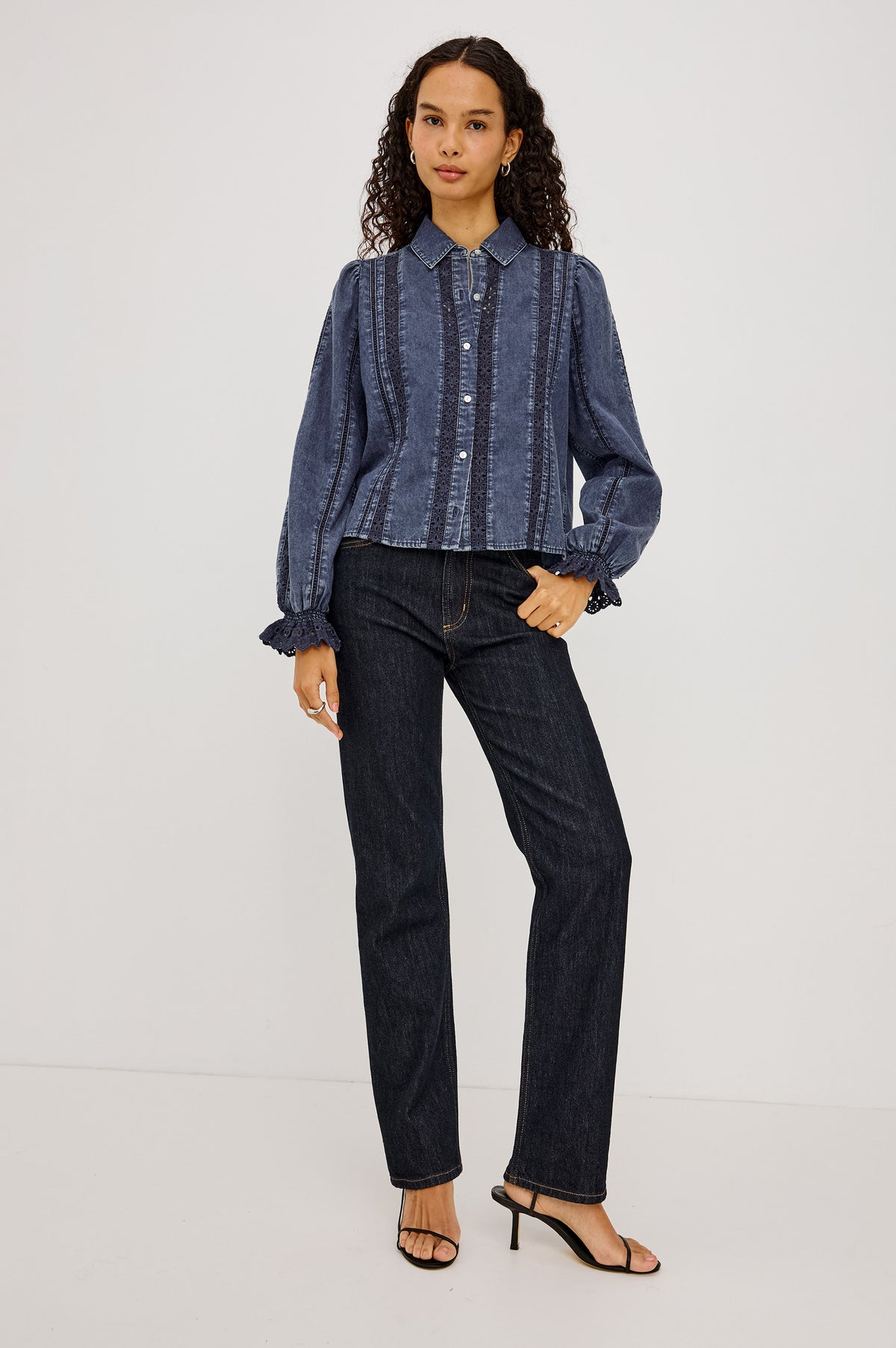 Rowen Shirt in Cotton Chambray With Cropped, Boxy Fit, Front Buttons, Long Puff Sleeves, Contrast Semi-Sheer Eyelet Panels, and Embroidered Trim at Collar and Flared Cuffs in Classic Blue Colorway - Full Body From View Featured on Model