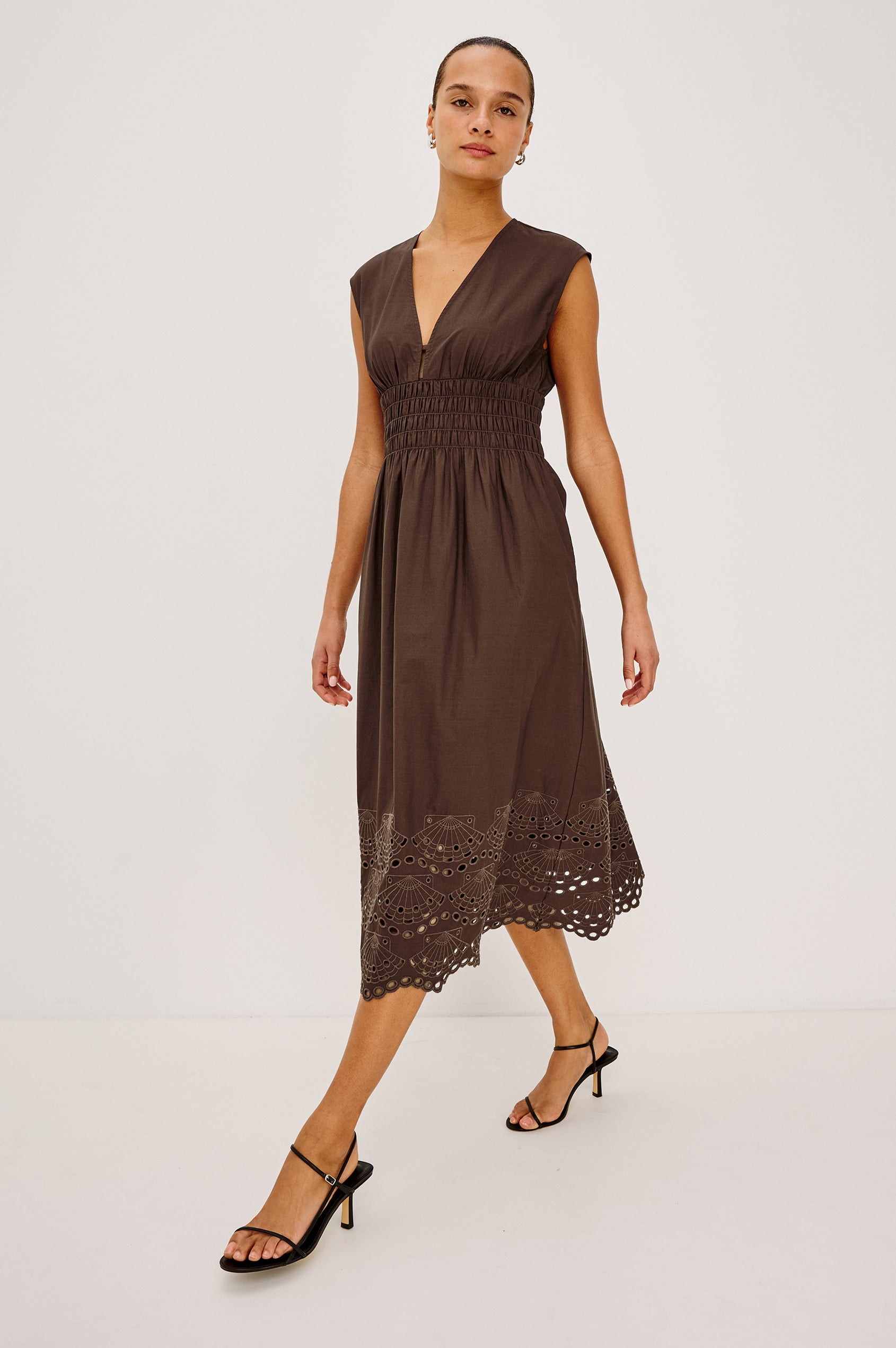 Roxanne Midi Dress in Cotton Poplin With Shirred Shoulders, Plunging V-Neck, Smocked Waist and Seashell Hem Embroidery in Espresso Colorway - Full Body Front View Featured on Model