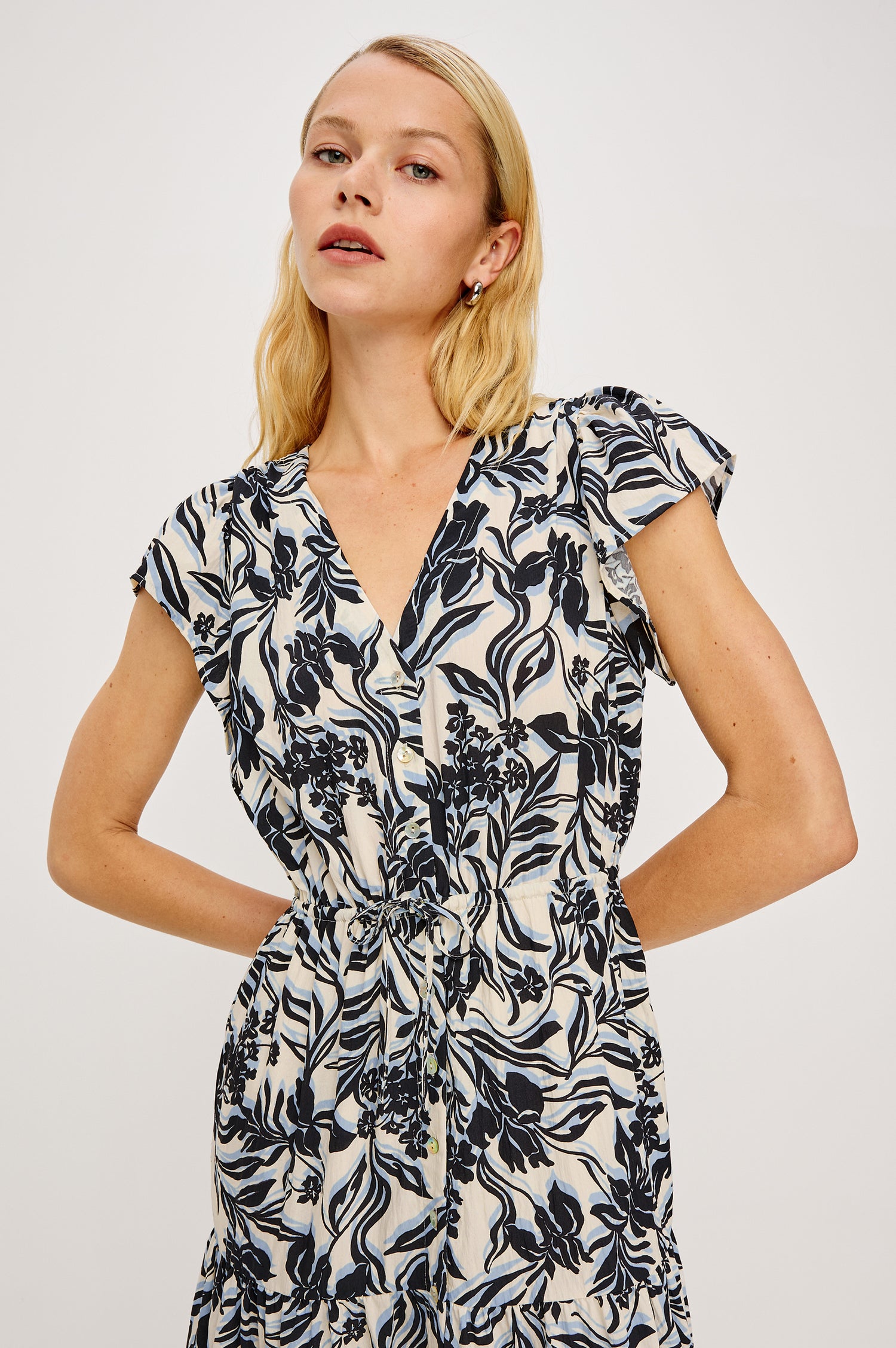 Roza Midi Dress in Cotton Poplin With V-Neckline Flutter Sleeves Front BUttons Adjustable Waist Ties and Tiered Lined Skirt in Zinya Colorway - Upper Body Front View Featured on Model