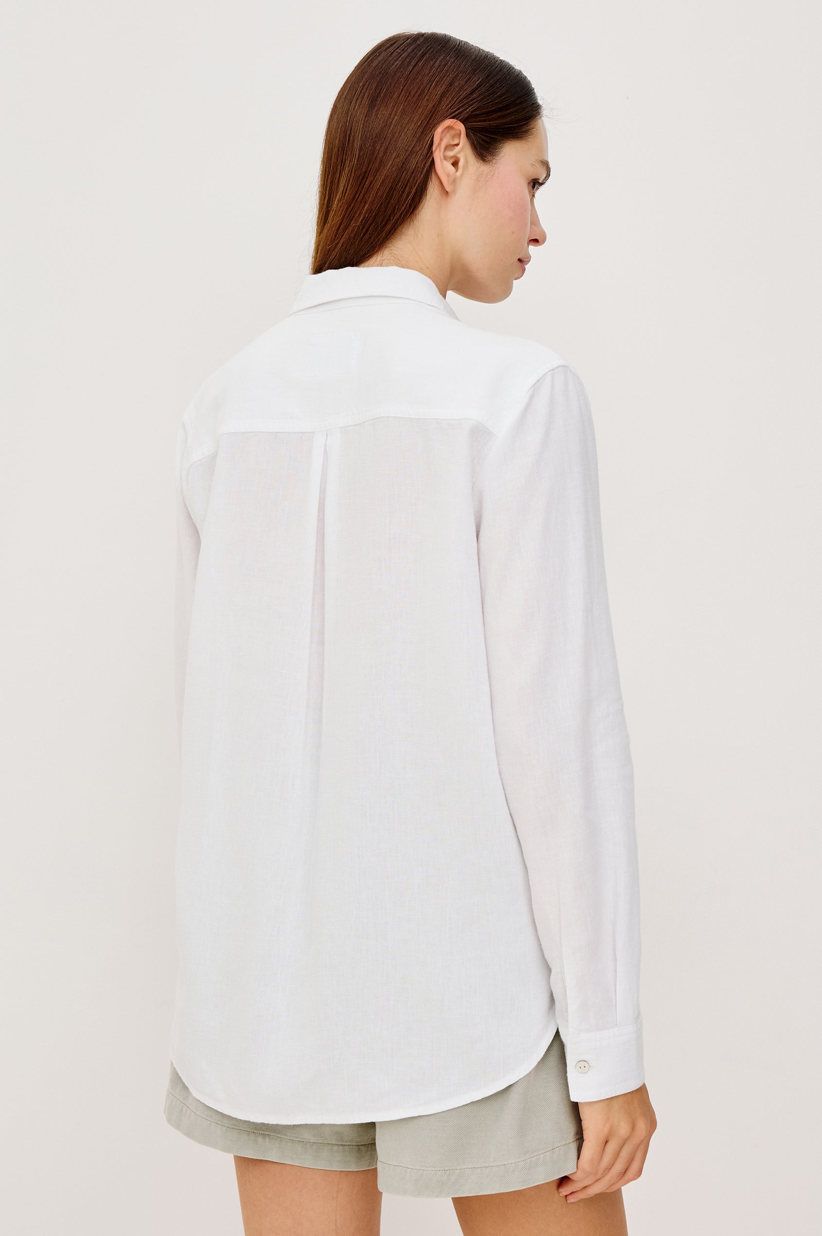 Samar Button-Up Collared Shirt in Linen With Palm Tree Eyelet Embroidery, Relaxed Fit, and Long Sleeves in White Palm Embroidery Colorway - Upper Body Back View Featured on Model
