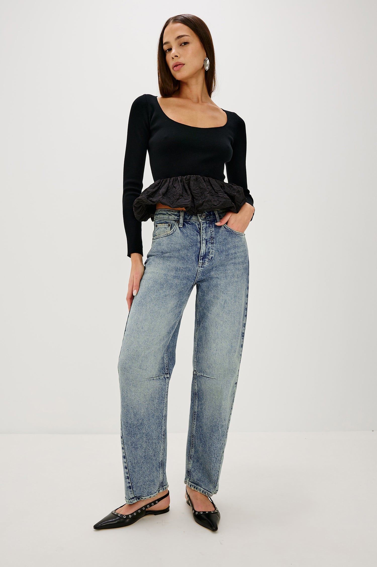 The Samo is a denim barrel leg jean, it features a low-slung fit in light-stretch denim with darting details and a subtle curved seam in Desert Sky wash, a vintage wash with yellow tint. Front full body view featured on model.