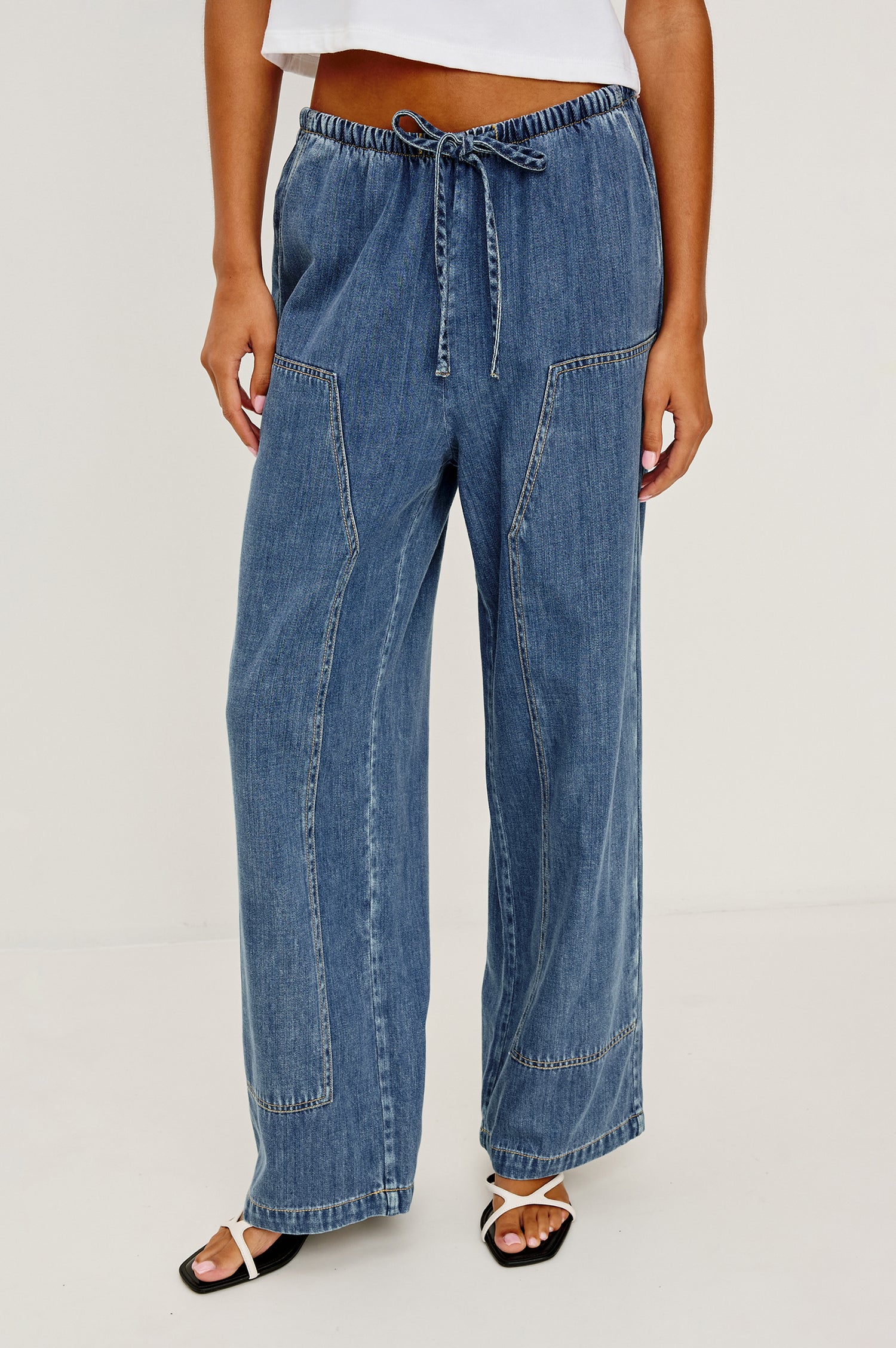 The Sanderson is a wide leg pull on pant with an encased drawstring waist tie, it has workwear inspired contrast topstitching on the front leg panels. Front view featured on model.