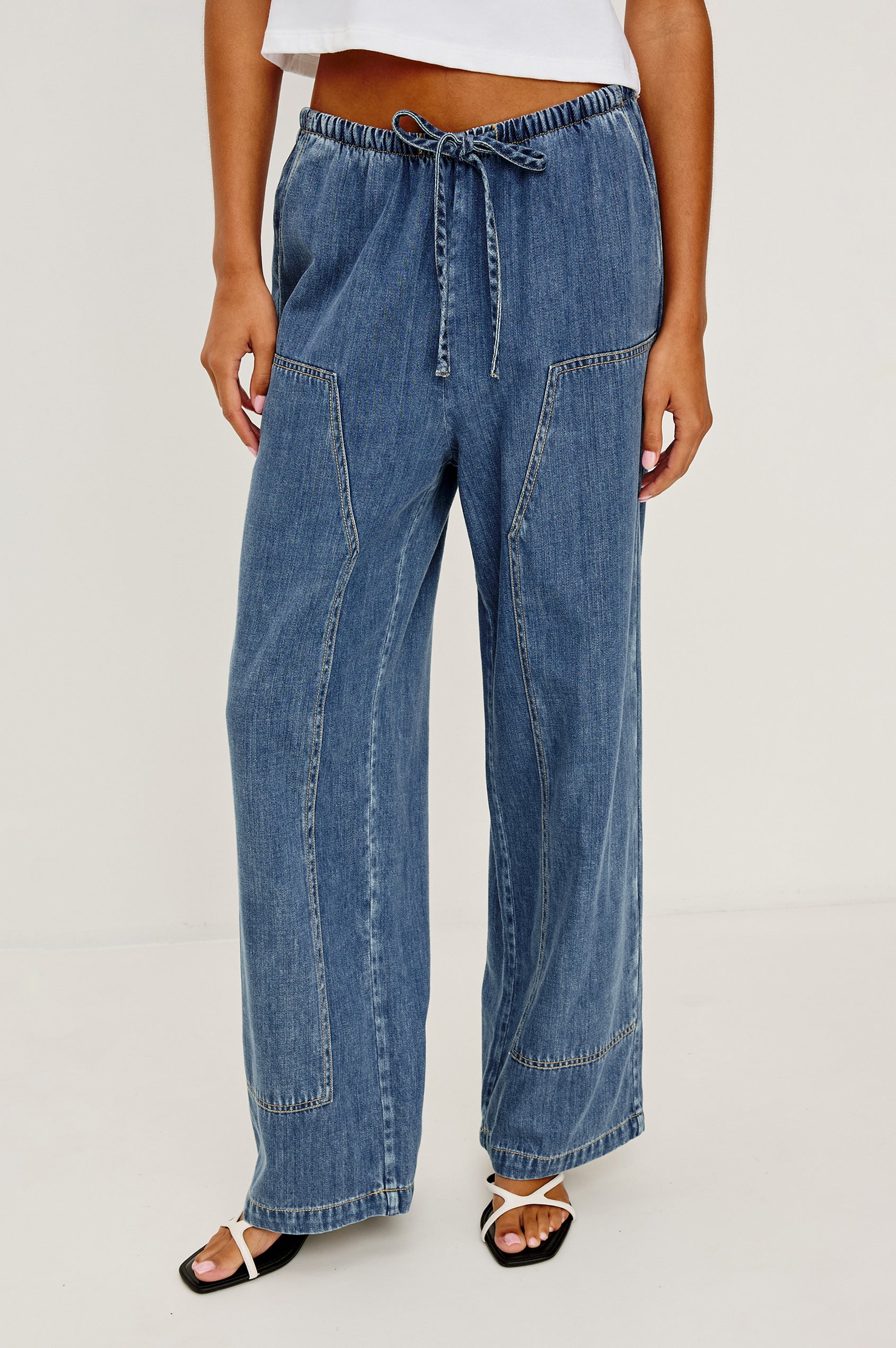 The Sanderson is a wide leg pull on pant with an encased drawstring waist tie, it has workwear inspired contrast topstitching on the front leg panels. Front view featured on model.