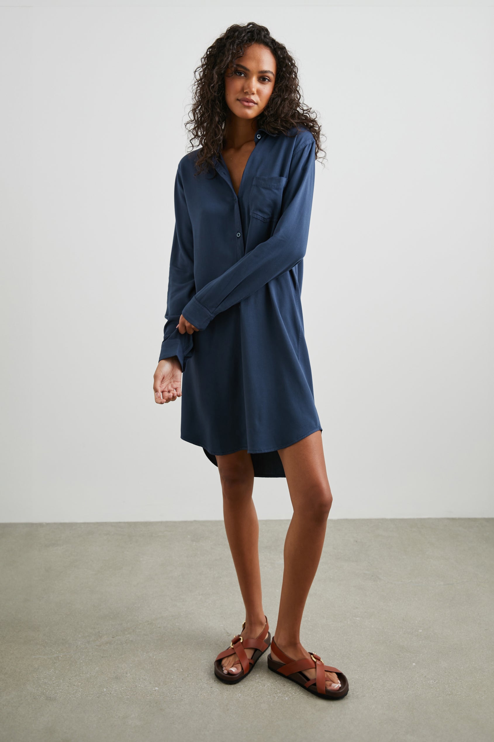 Sawyer Long-Sleeve Mini Dress with a Full Button Front, a Chest Patch Pocket, a Collar, Button Cuffs and a Low High Hem in Navy Colorway - Front Full Body View Featured on Model 
