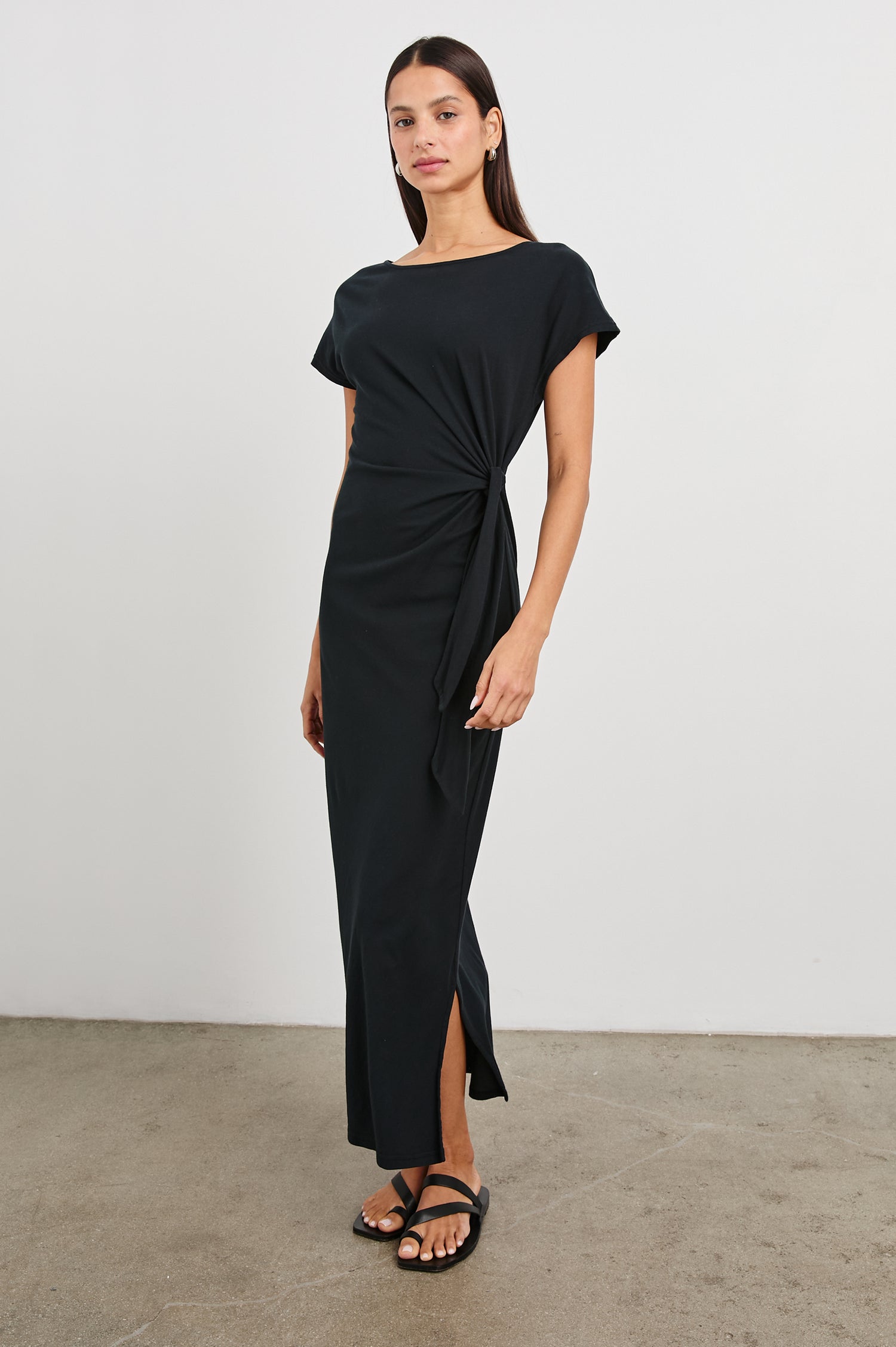 Selah Maxi Dress with Short Sleeves, Boatneck, Adjustable Side Tie at Waist and Two Mid-Calf Side Slits in Black Colorway  - Front Full Body View Featured on Model