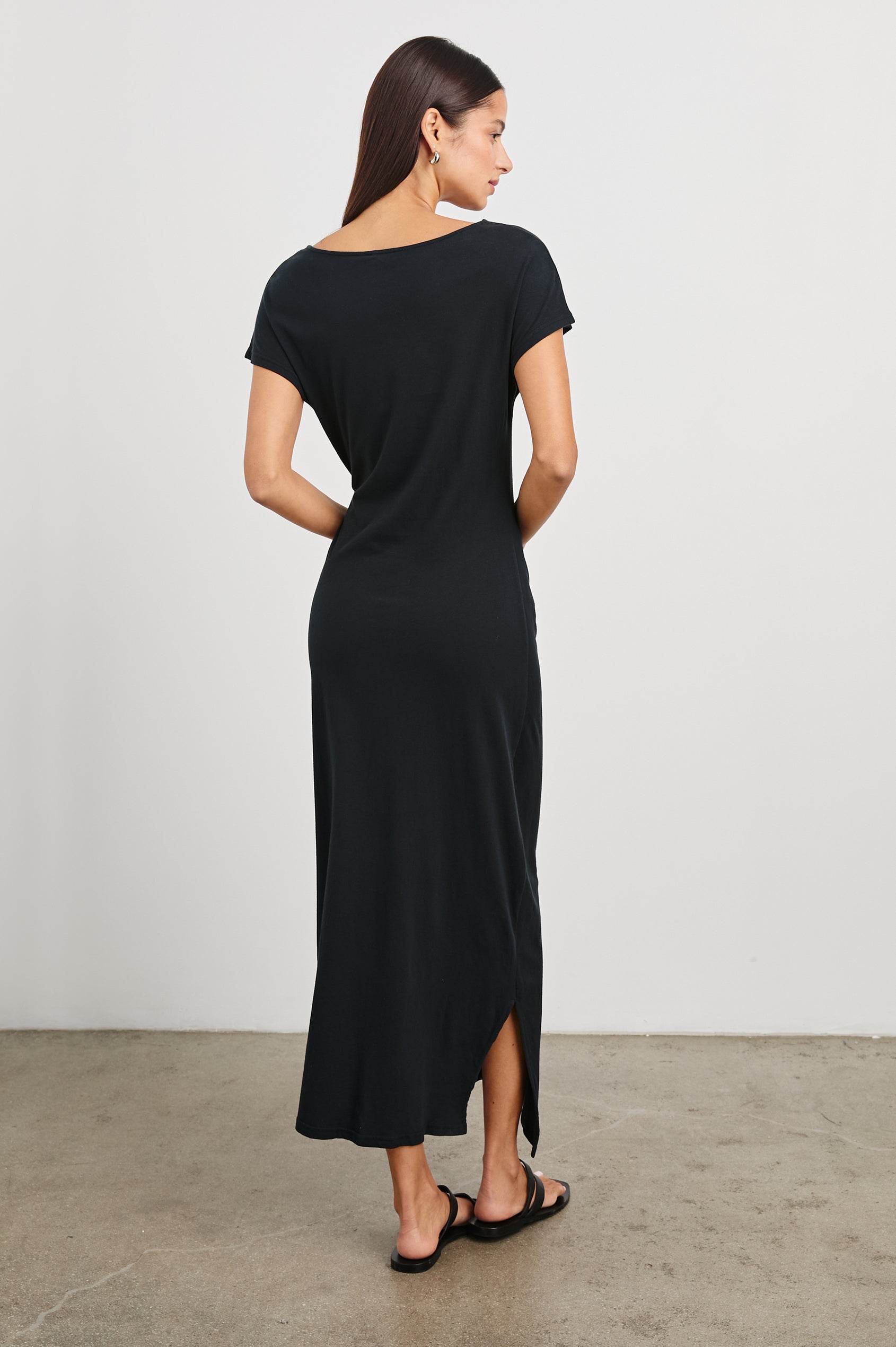 Selah Maxi Dress with Short Sleeves, Boatneck, Adjustable Side Tie at Waist and Two Mid-Calf Side Slits in Black Colorway  - Back Full Body View Featured on Model